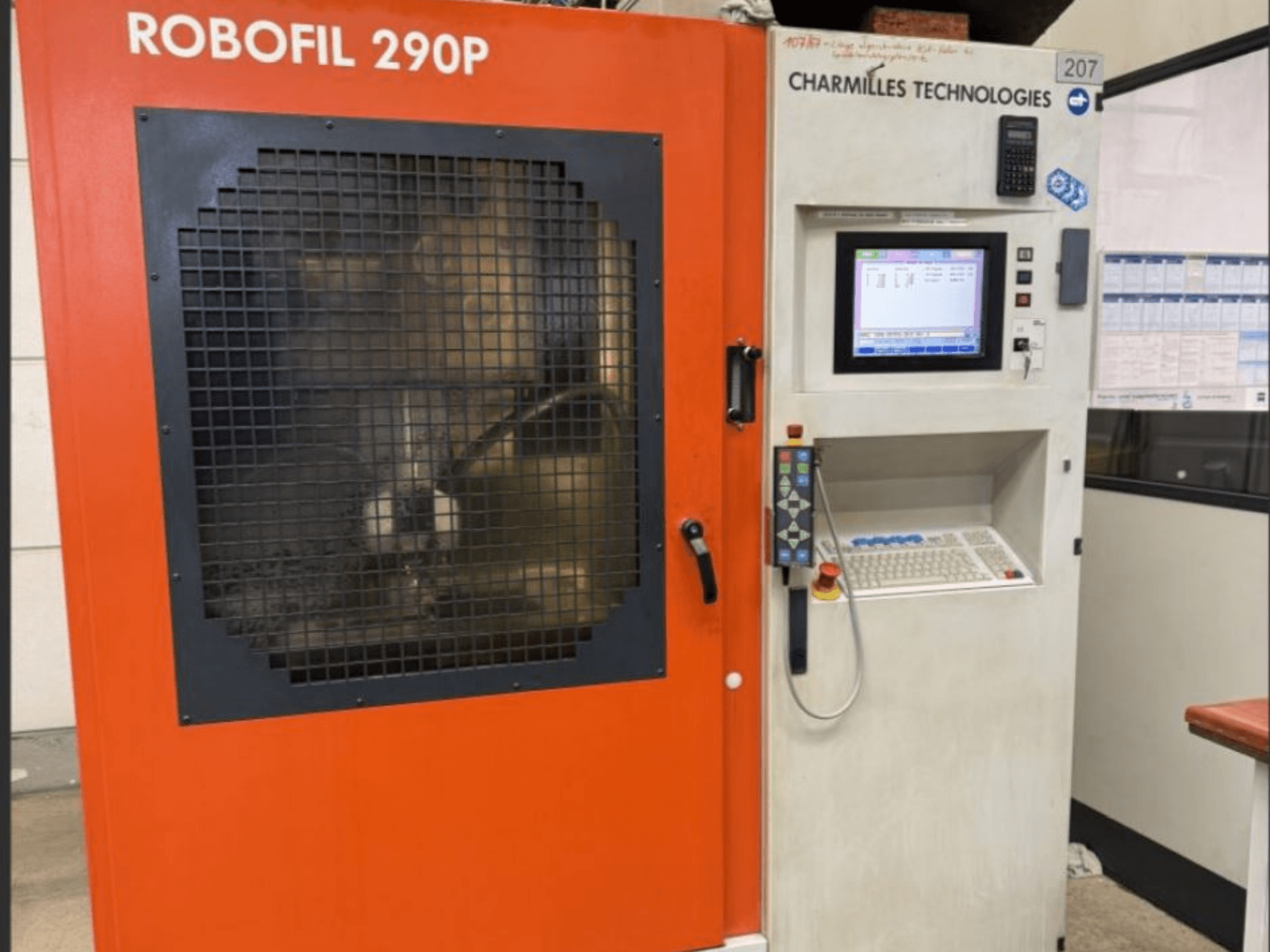 CHARMILLES TECHNOLOGIES Robofil 290P tel EDM makinesinin kontrol paneli ve ızgara korumalı çalışma alanı ile önden görünümü.