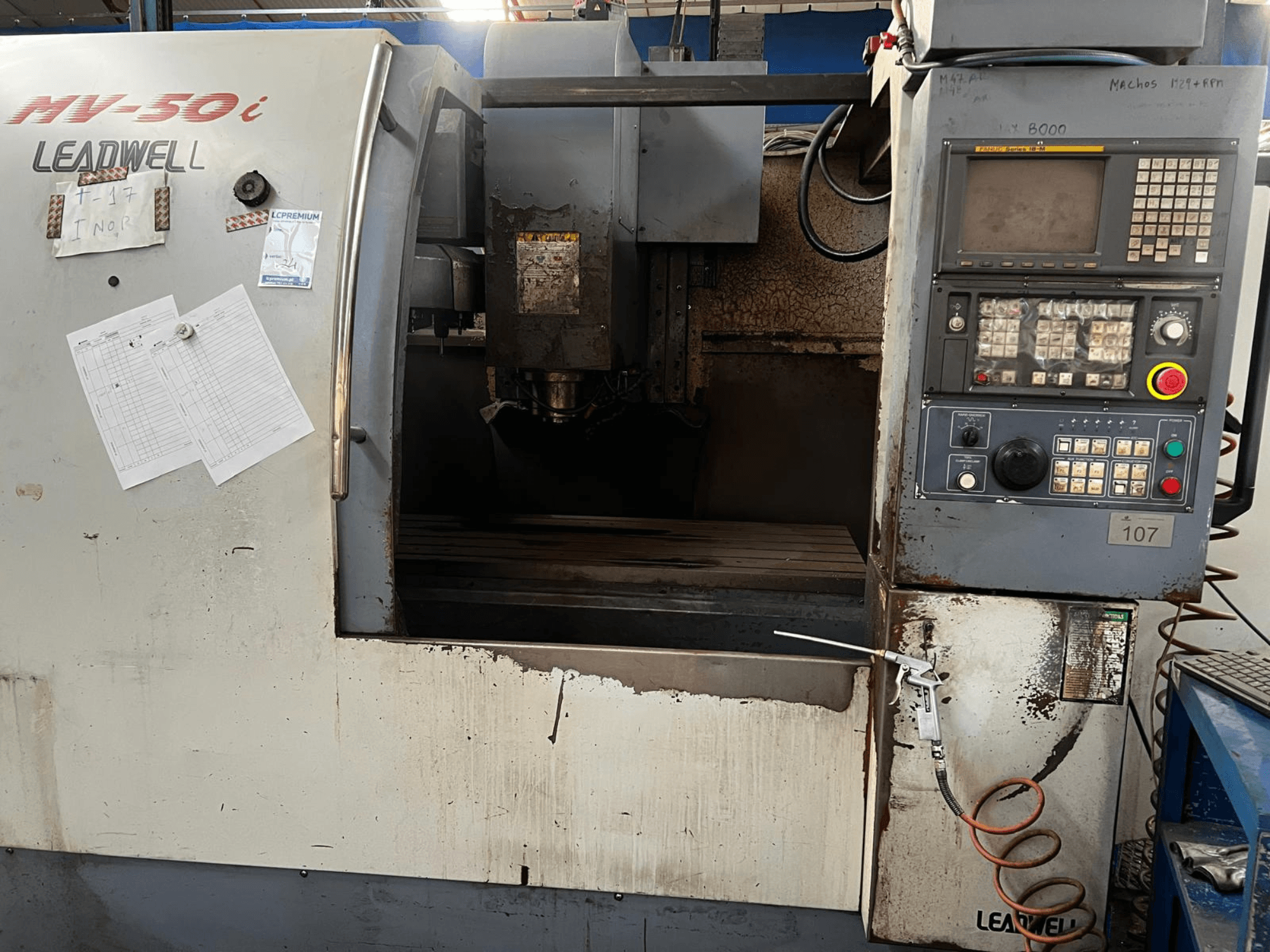 Leadwell MV-50i dikey işleme merkezi, önden görünüm; kontrol paneli, iş mili bölgesi ve aşınma izleri bulunan iş masası görülmektedir.