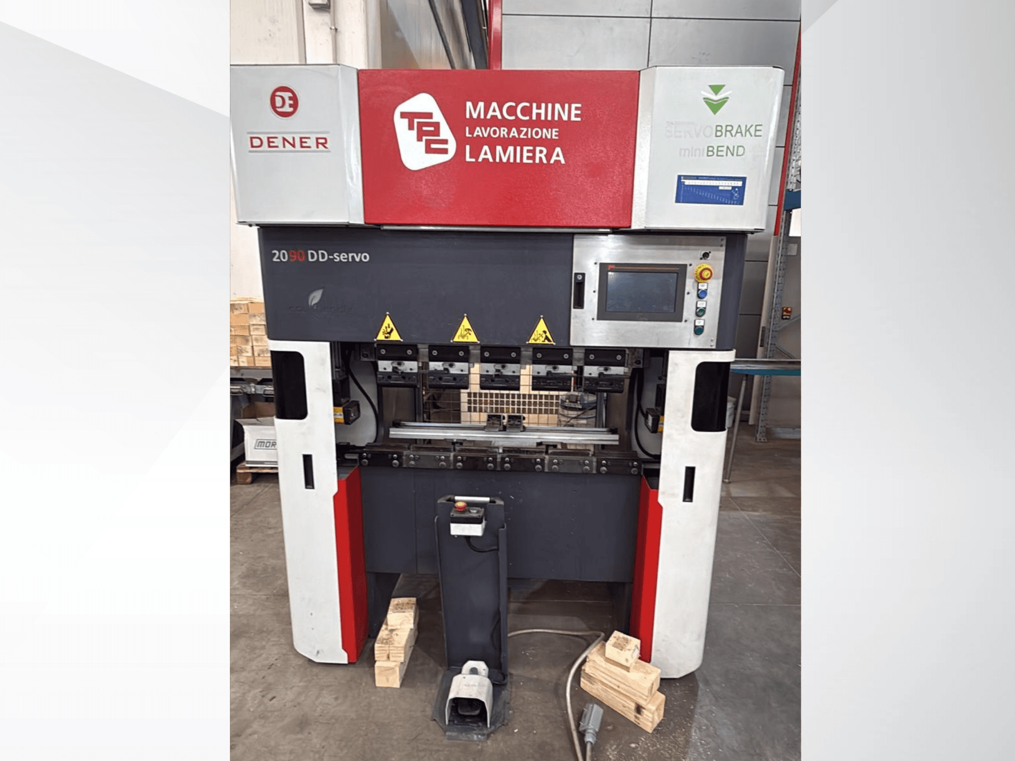DENER DDS 2090 pres freninin önden görünümü; kontrol paneli, güvenlik etiketleri ve ahşap taban desteği ile birlikte.