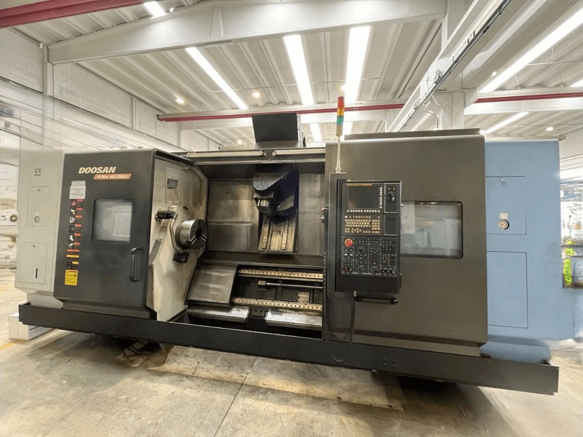 Kontrol paneli, iş mili ve takım tutucu bölümü açıkça görülebilen bir DOOSAN PUMA MX3100 yatay torna tezgahının önden görünümü.