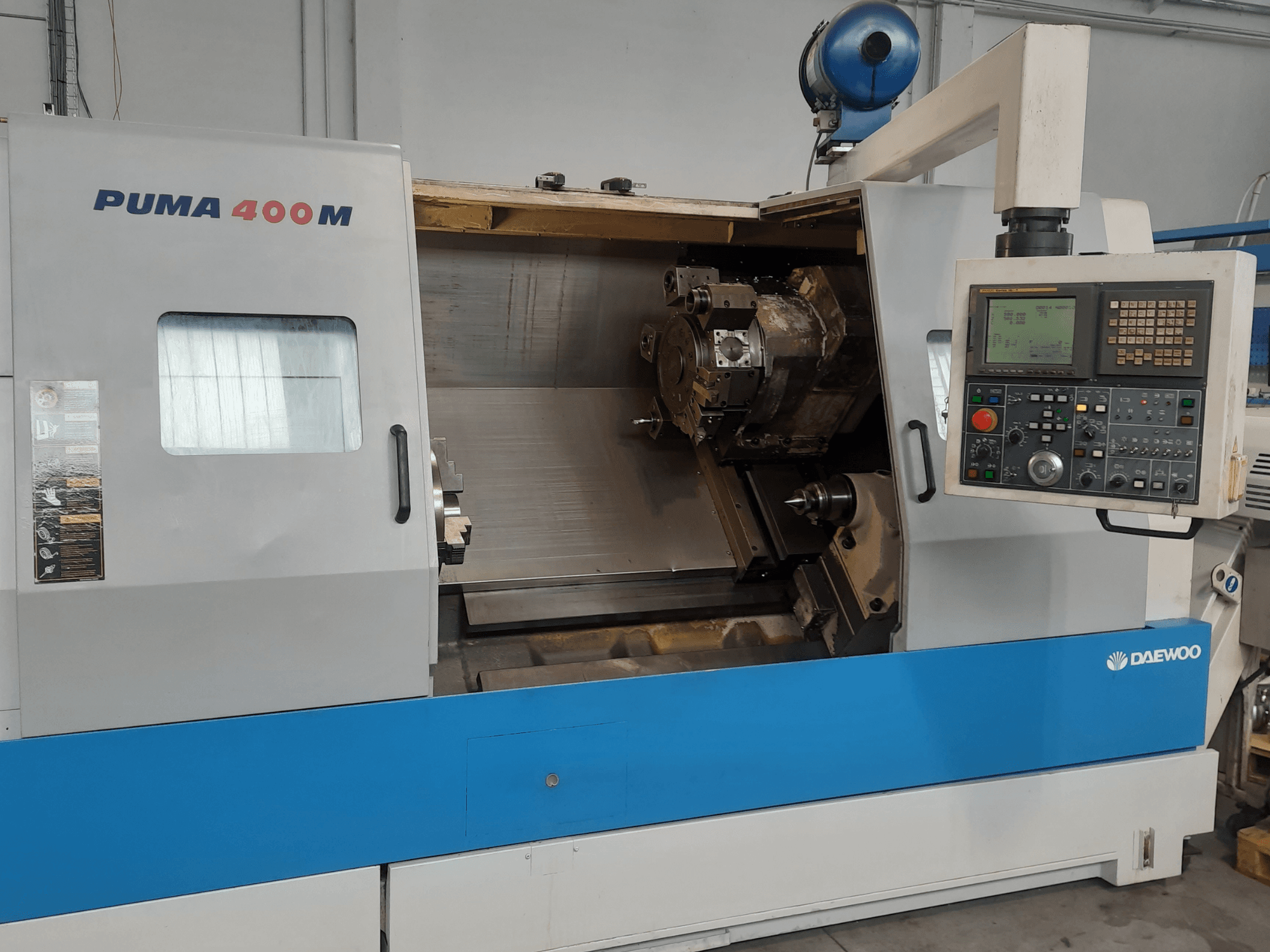 DAEWOO PUMA 400MB yatay torna tezgahının önden görünümü; tezgahın kontrol paneli ve işleme odasındaki kesici alet görülebilir.