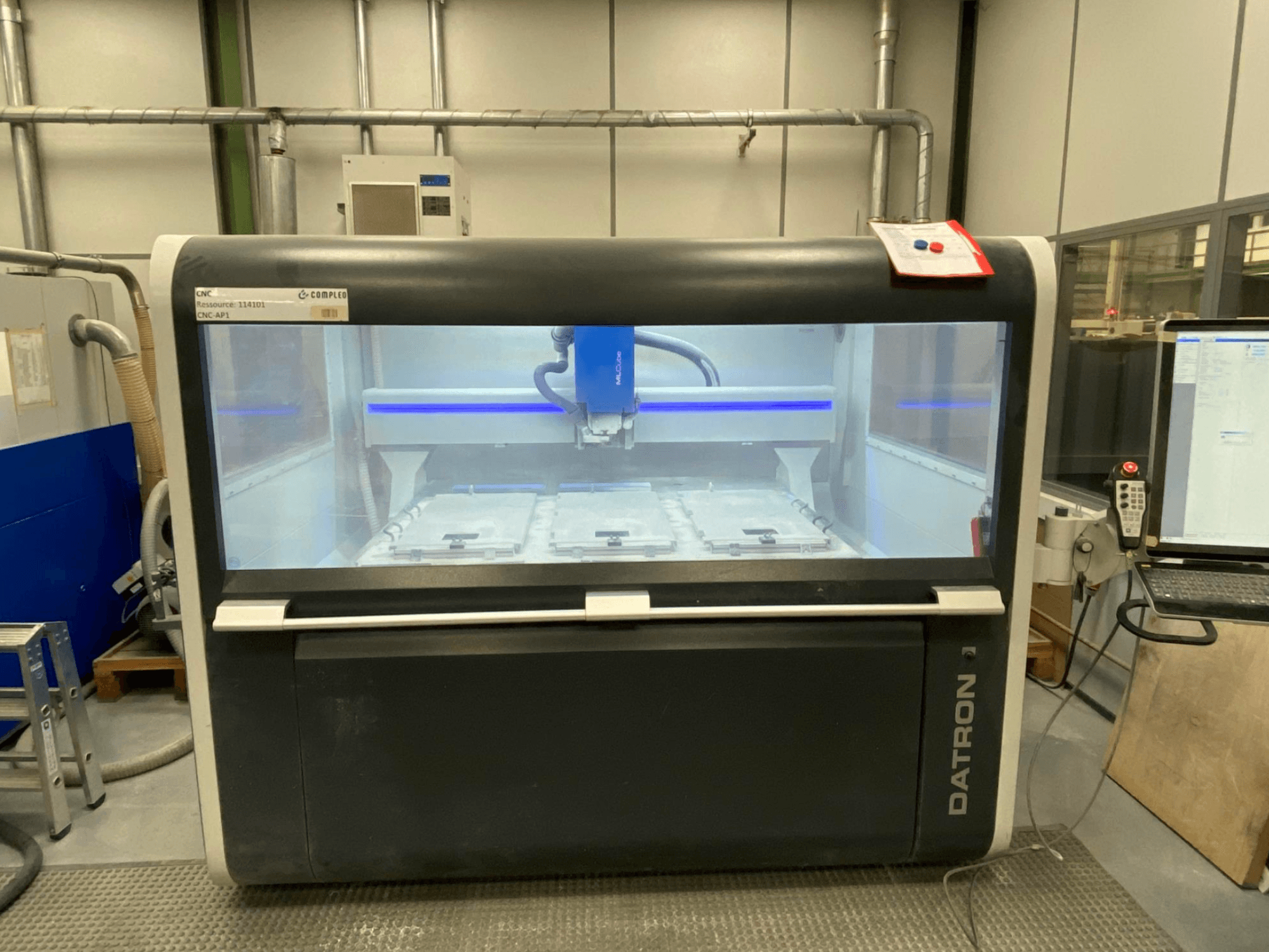 Datron MLCube B dikey işleme merkezi, önden görünüm, makinenin iç kısmını ve kontrol panelini sergiliyor.