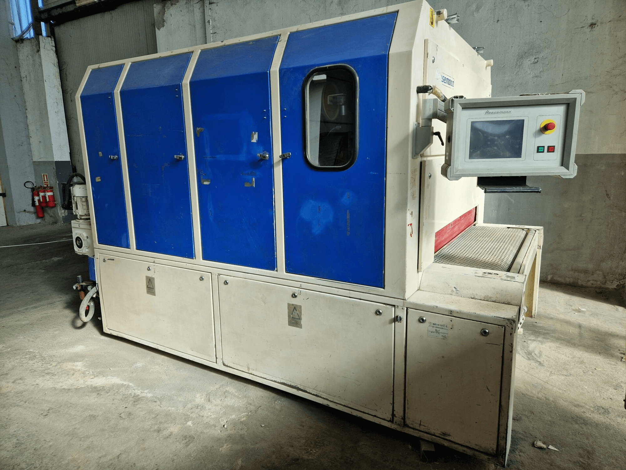 "Sedecom" markalı endüstriyel makine, yandan görünüm; mavi paneller, bir kontrol ekranı ve ürünleri taşımak için dokulu bir yüzeye sahiptir.