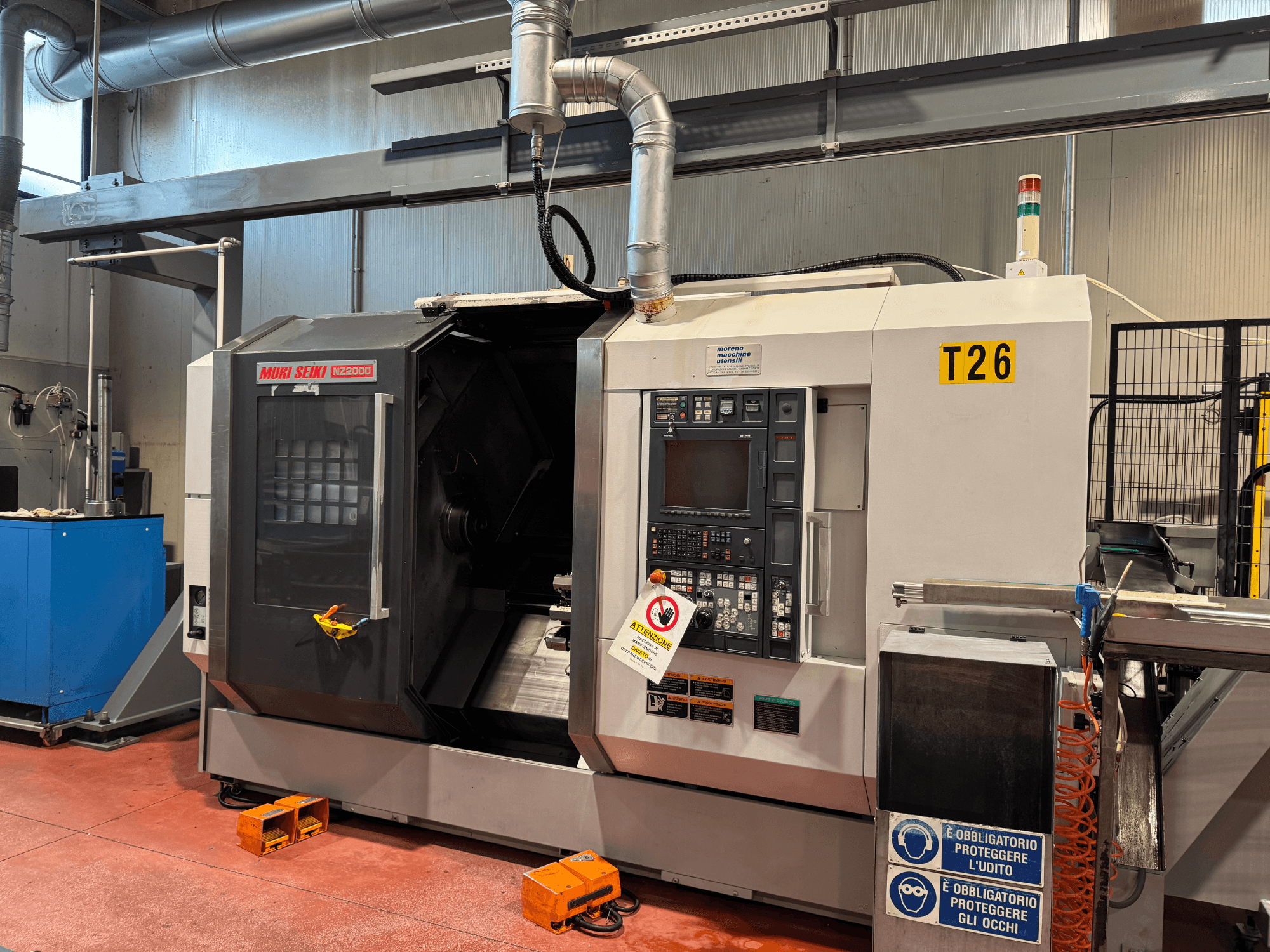 MORI SEIKI NZ-2000/T2/Y2 torna freze merkezi, önden görünüm, kontrol paneli, güvenlik işaretleri ve endüstriyel kurulum özellikleri.