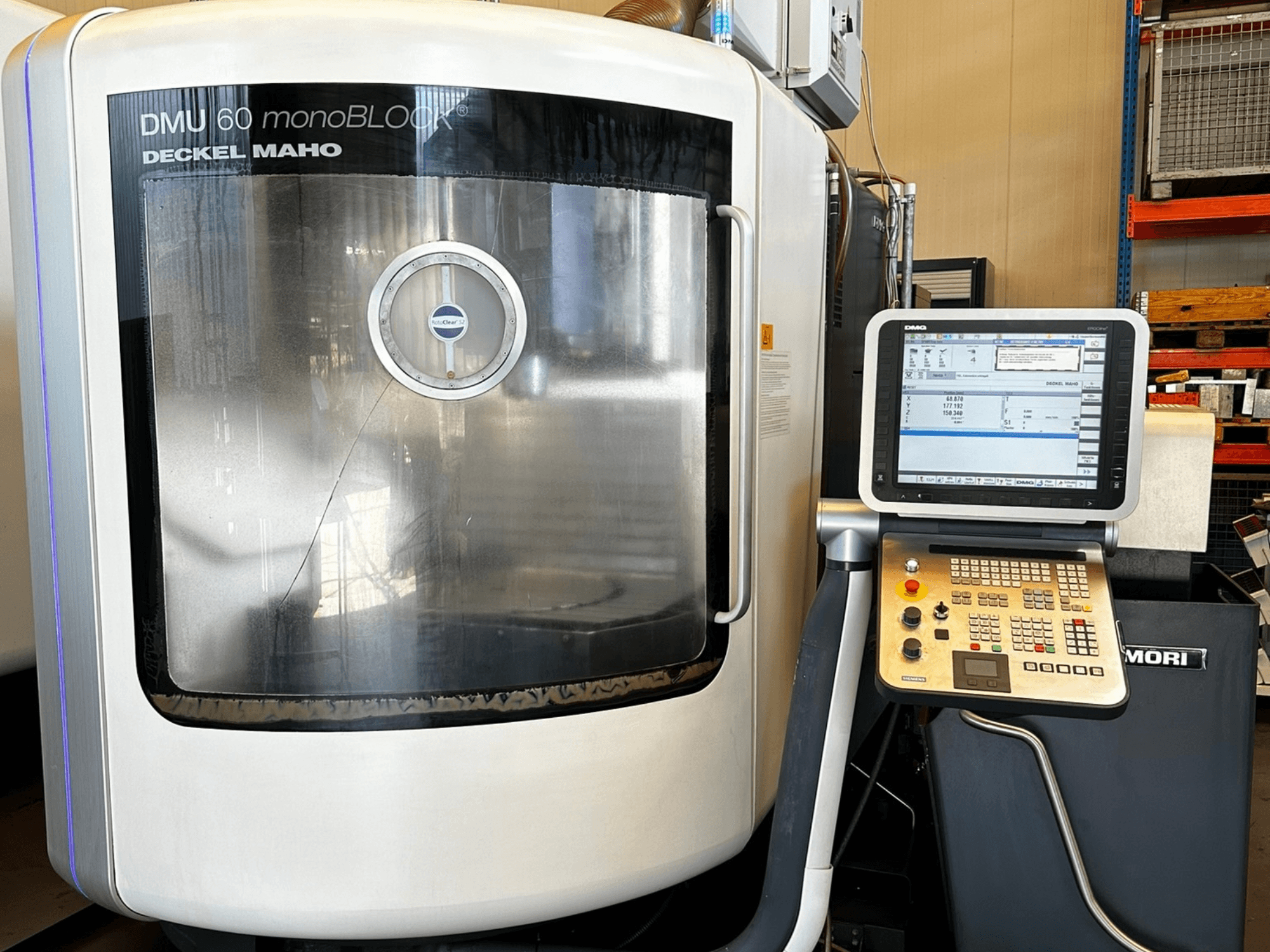 DMG MORI DMU 60 monoBLOCK dikey işleme merkezi, önden görünüm, dokunmatik kontrol paneli ve yansıtıcı pencere.