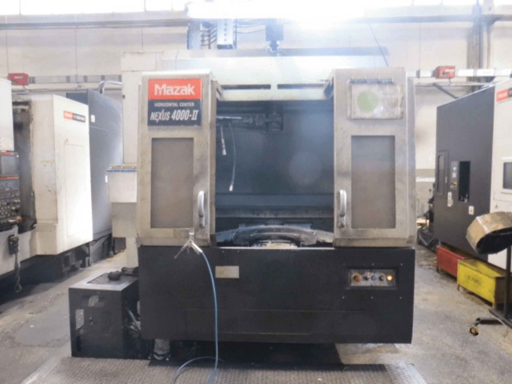 Mazak NEXUS 4000 II yatay işleme merkezi; kontrol paneli, soğutma sıvısı beslemesi ve açık iş alanını gösteren önden görünüm.