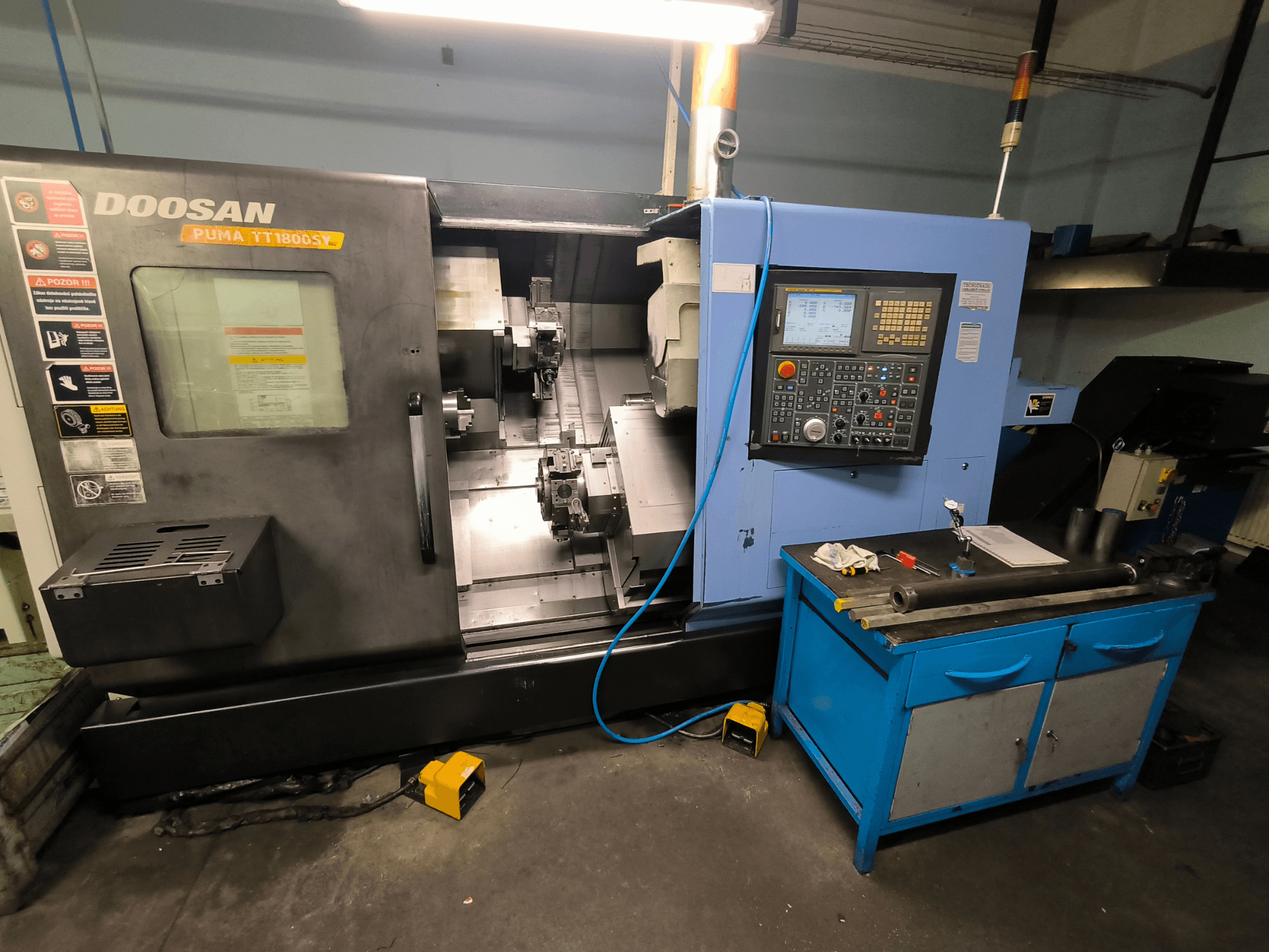 Doosan Puma TT1800SY CNC torna tezgahı, önden görünüm, kontrol panelini, aletlerle çalışma alanını ve makine bileşenlerini gösterir.