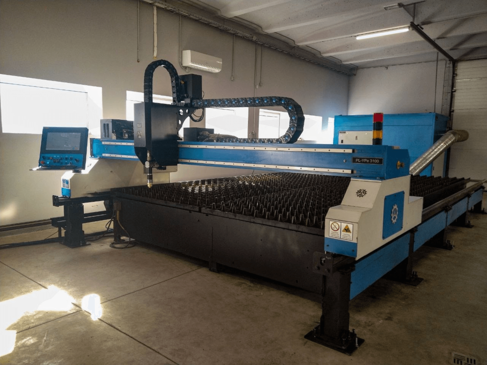 INANMAK MEKOR PL-YPe 3100 plazma kesme makinesi, önden görünüm, kontrol paneli ve yükseltilmiş metal çivili kesme tablası.