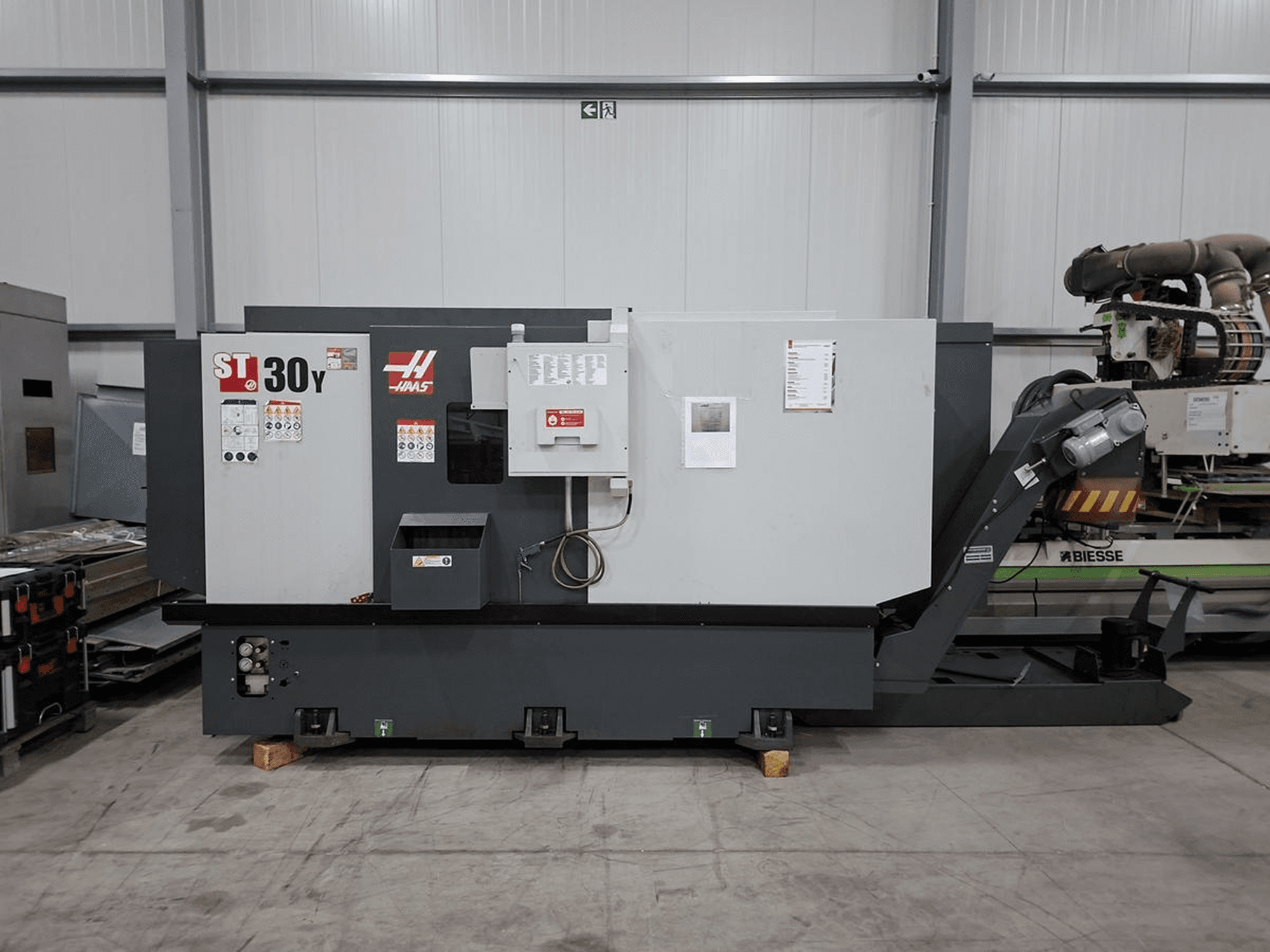 Haas ST-30Y yatay torna tezgahının yandan görünümü; geniş bir atölye ortamında kontrol panelleri, etiketler ve sağlam yapısı göze çarpıyor.