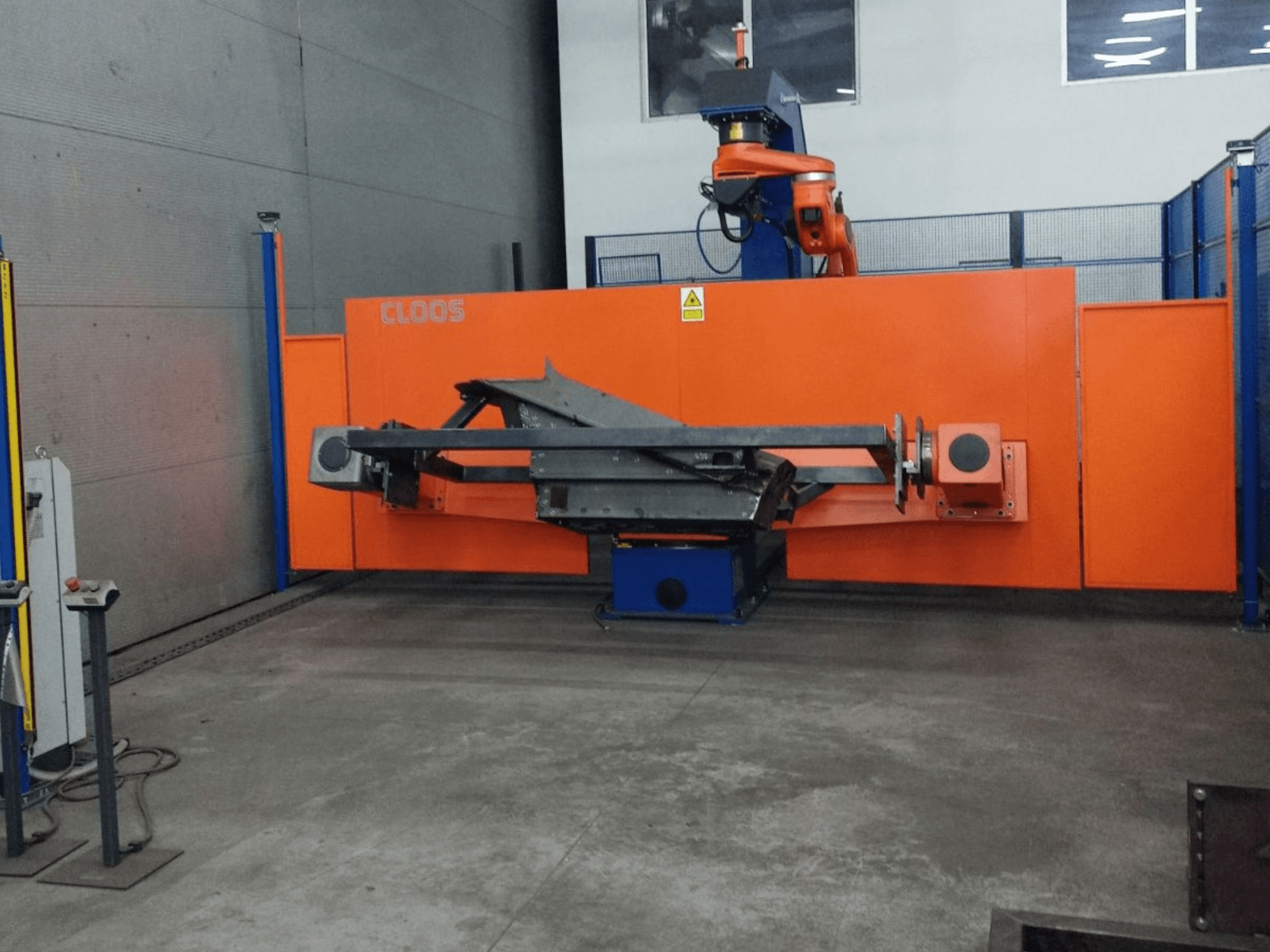 CLOOS QIROX QRC-350-E otomasyon sisteminin robotik kol ve metal yapı ile endüstriyel ortamda önden görünümü.