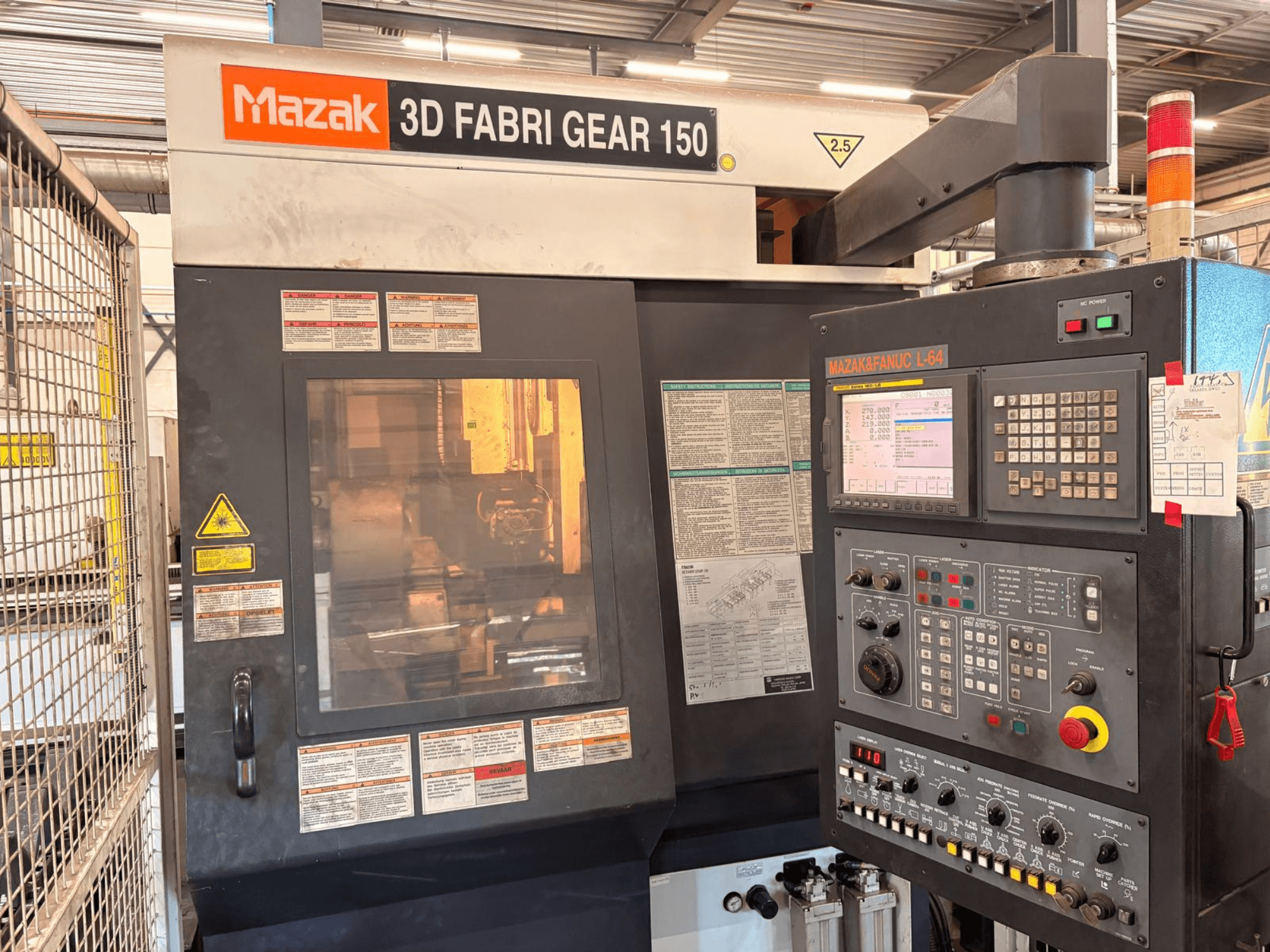 Mazak 3D Fabri Gear 150 boru kesme makinesi; kontrol paneli, güvenlik etiketleri ve kullanım arayüzünü gösteren önden görünüm.