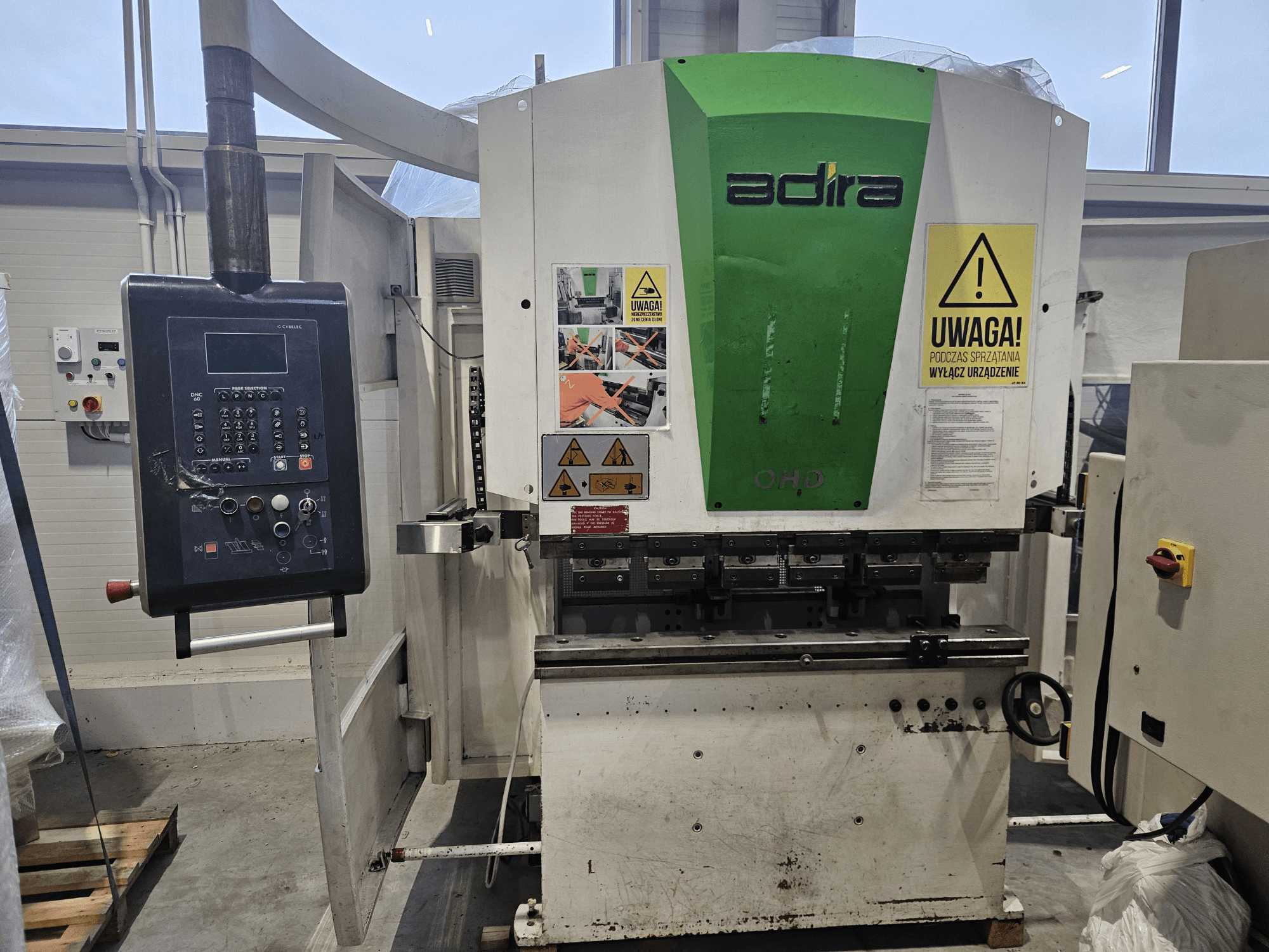 Adira OHD makinesinin önden görünümü, kontrol paneli, güvenlik uyarıları ve çalıştırma düğmeleri.