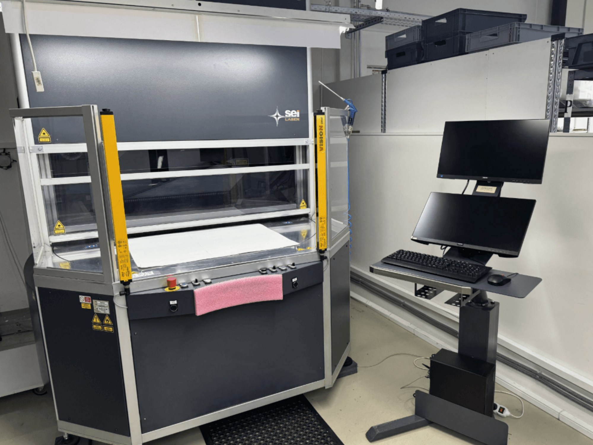 SEI Laser INFINITY 5070 V300 CO₂ lazer kesim makinesinin önden görünümü; kontrol paneli ve bağlı monitör ünitesi ile birlikte.