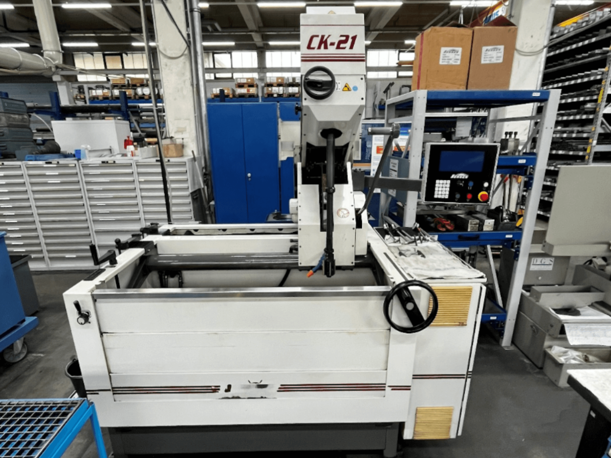 Önden görünümde Sunnen CK-21-CC dikey honlama makinesi, arka planda kontroller, honlama alanı ve destek ekipmanları.