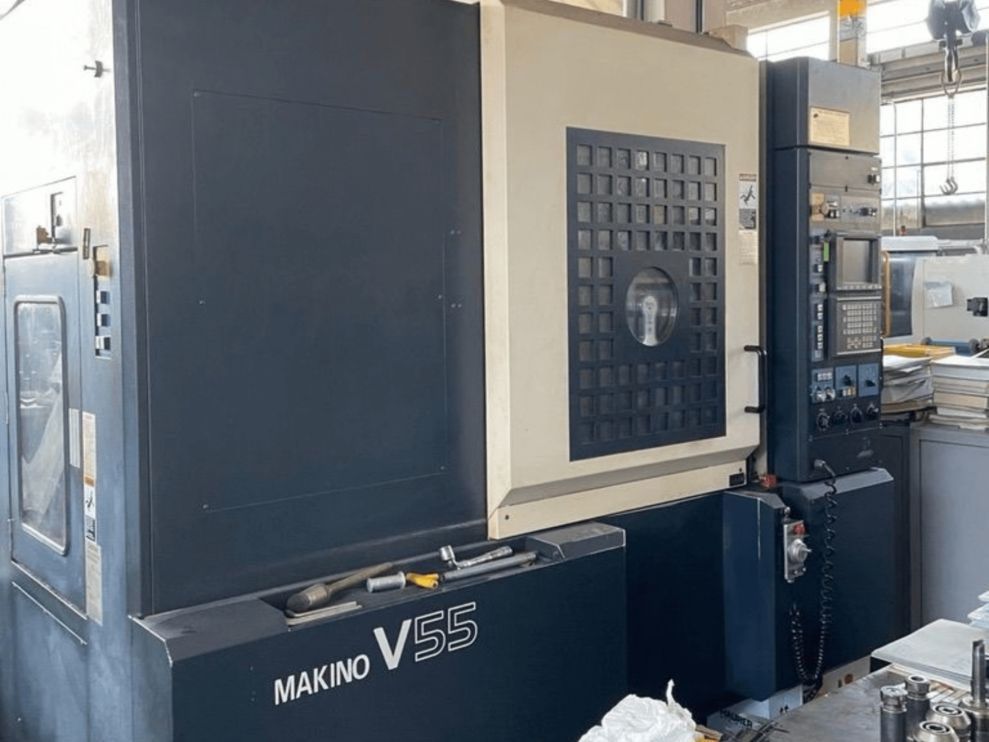 Makino V55-A15 dikey işleme merkezi; kontrol paneli, sağlam yapısı ve çalışma alanı düzenini gösteren önden görünüm.