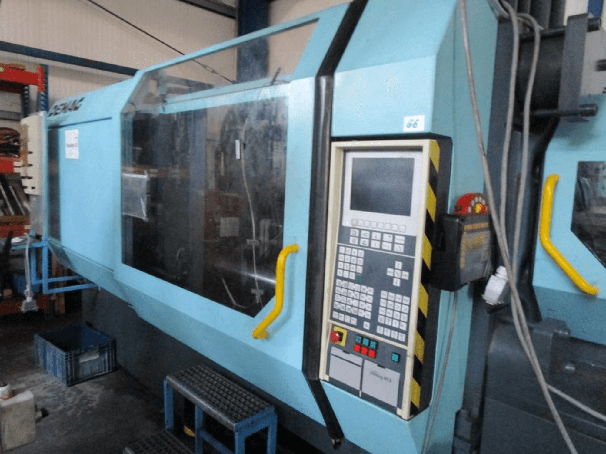 Demag Erdotech 500-3300 hidrolik enjeksiyon kalıplama makinesi, önden görünüm, kontrol paneli ve açık güvenlik muhafazası özellikleri.