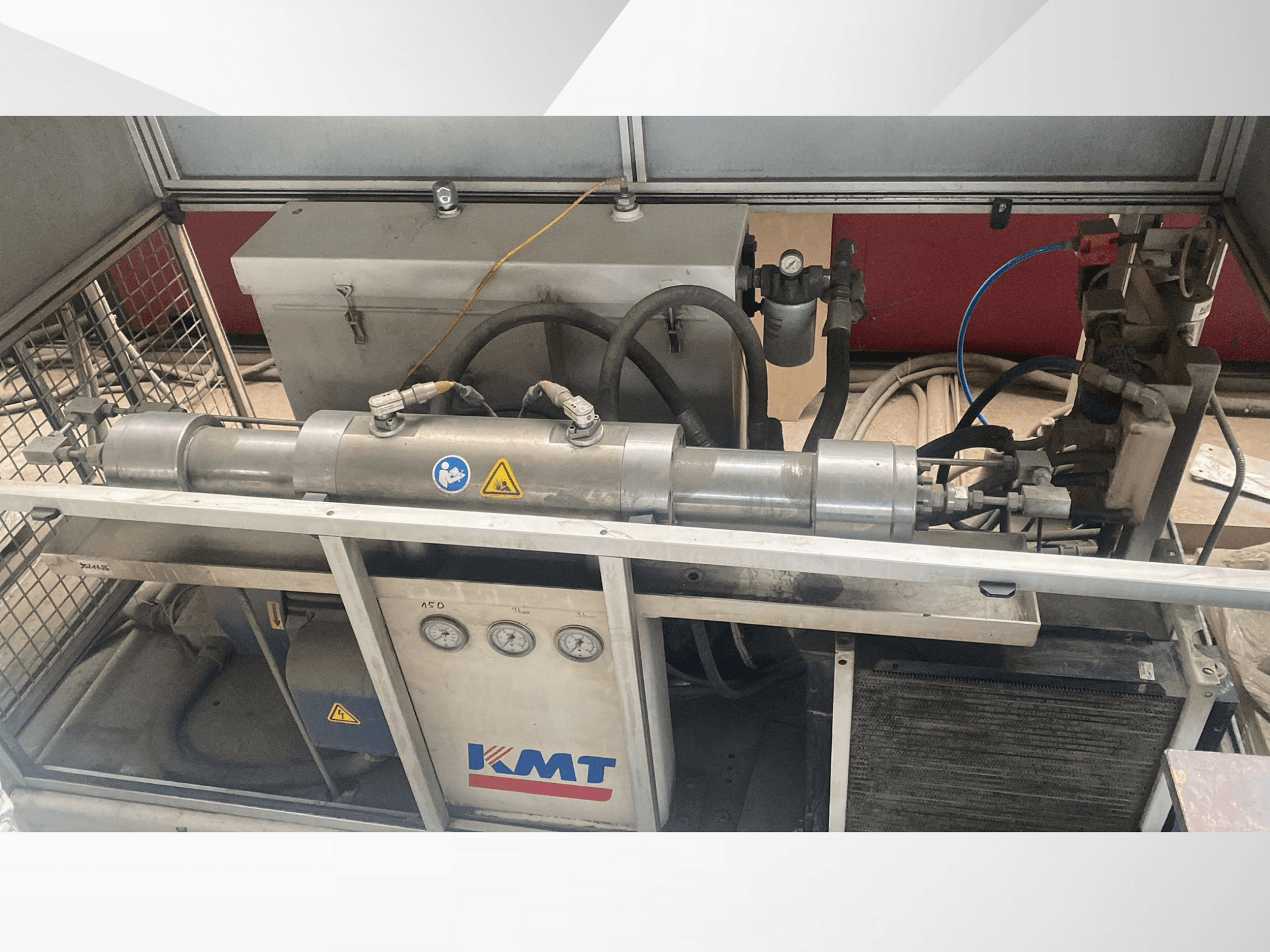 Önden görünümlü KMT hidrolik makine, basınç göstergeleri, hortumları ve metal gövdesi ile endüstriyel uygulamalar için idealdir.