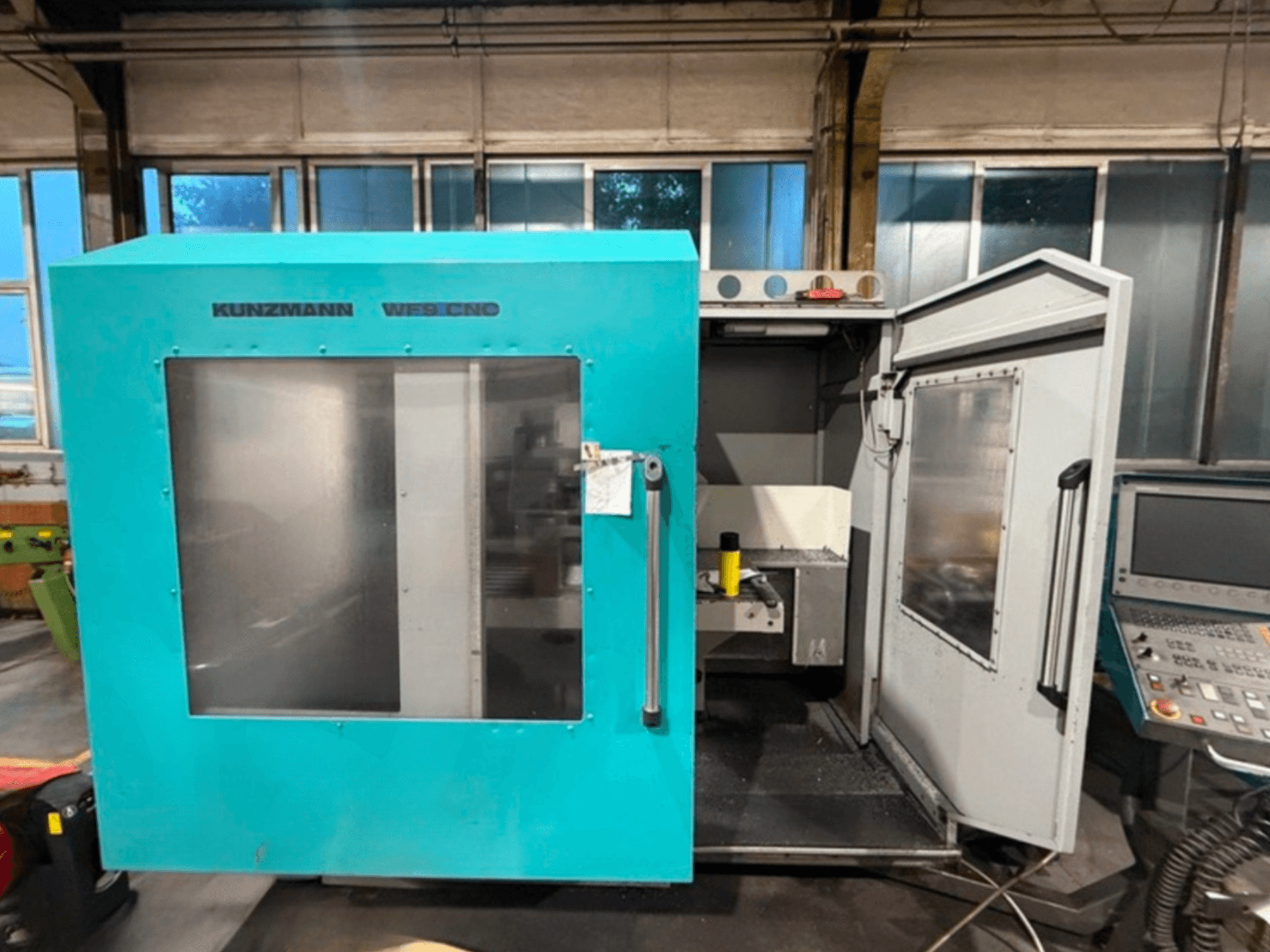 KUNZMANN WF9 CNC dik işleme merkezi, açık kapılarla önden görünüm, iç mekanı ve kontrol panelini gösterir.
