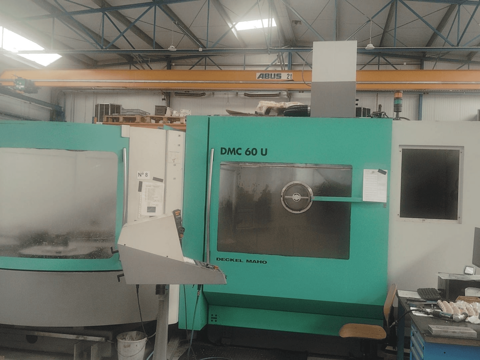 DECKEL MAHO DMC 60 U Mill-Turn Center'ın önden görünümü, kontrol paneli ve büyük cam izleme penceresi.