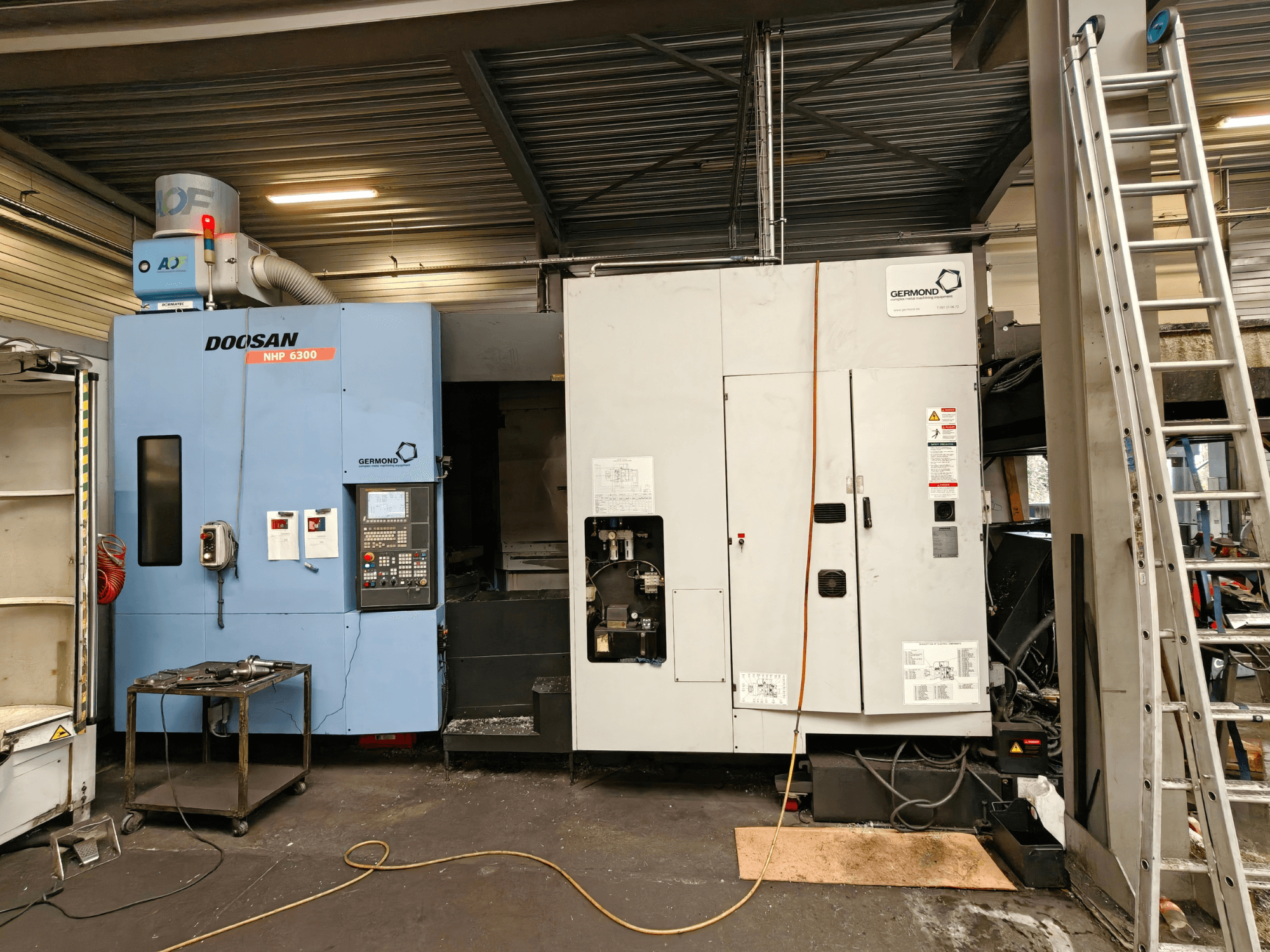 DOOSAN NHP6300 yatay işleme merkezinin önden görünümü; atölye ortamında kontrol paneli ve yanındaki makineler gösterilmektedir.