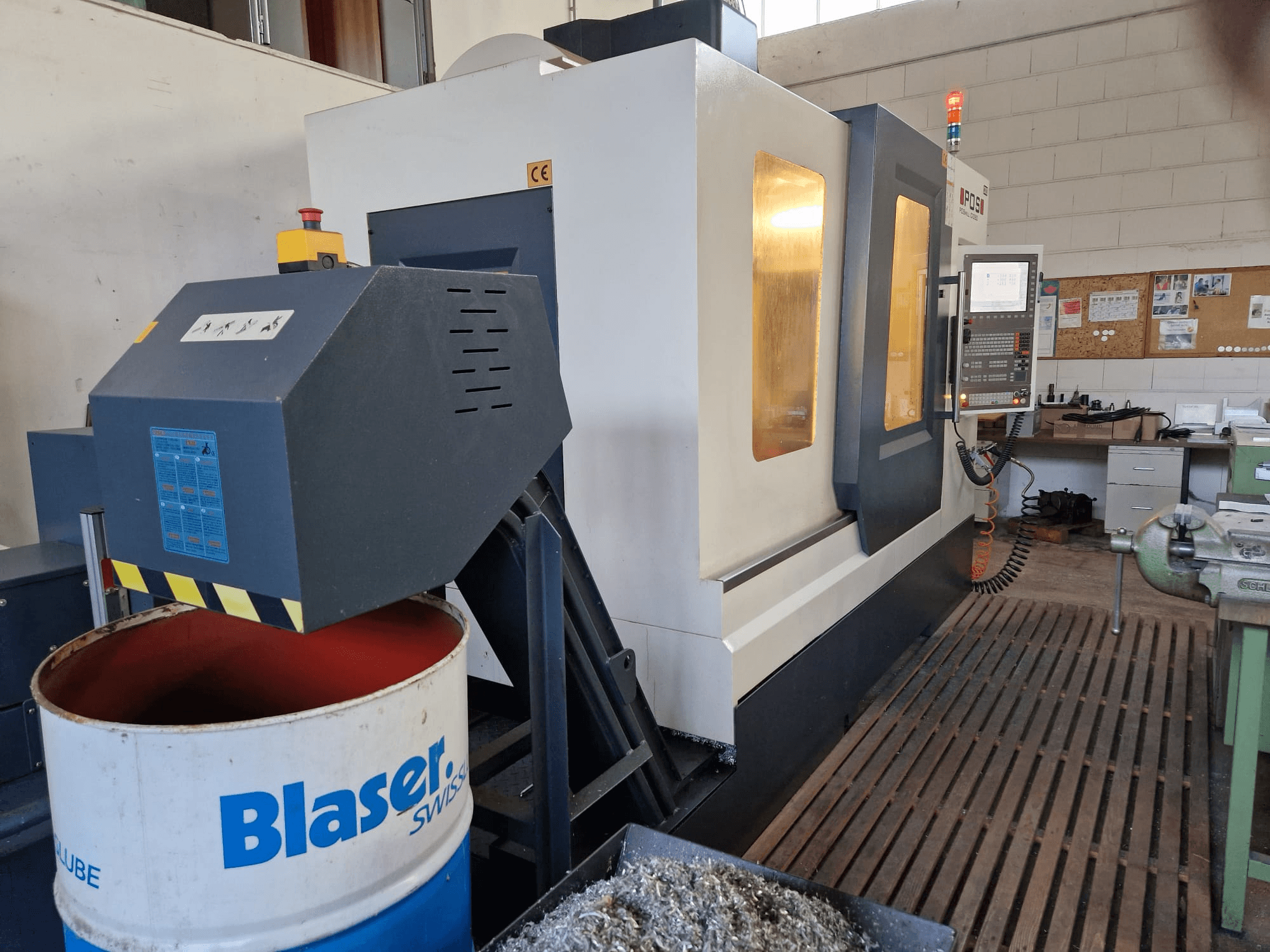 POSmill C 1050 dikey işleme merkezinin önden görünümü, Blaser tamburunun üzerindeki soğutma sistemi ve kontrol paneli görünür.