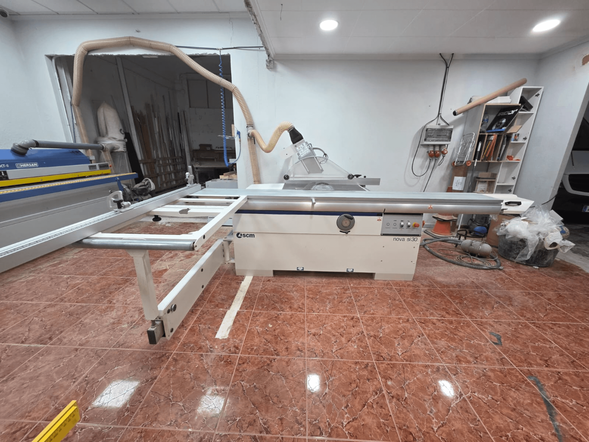 Bir atölyede bulunan SCM NOVA SI 30 panel testere, önden bakıldığında kesme masası ve şasi üzerindeki kumanda elemanları görülmektedir.