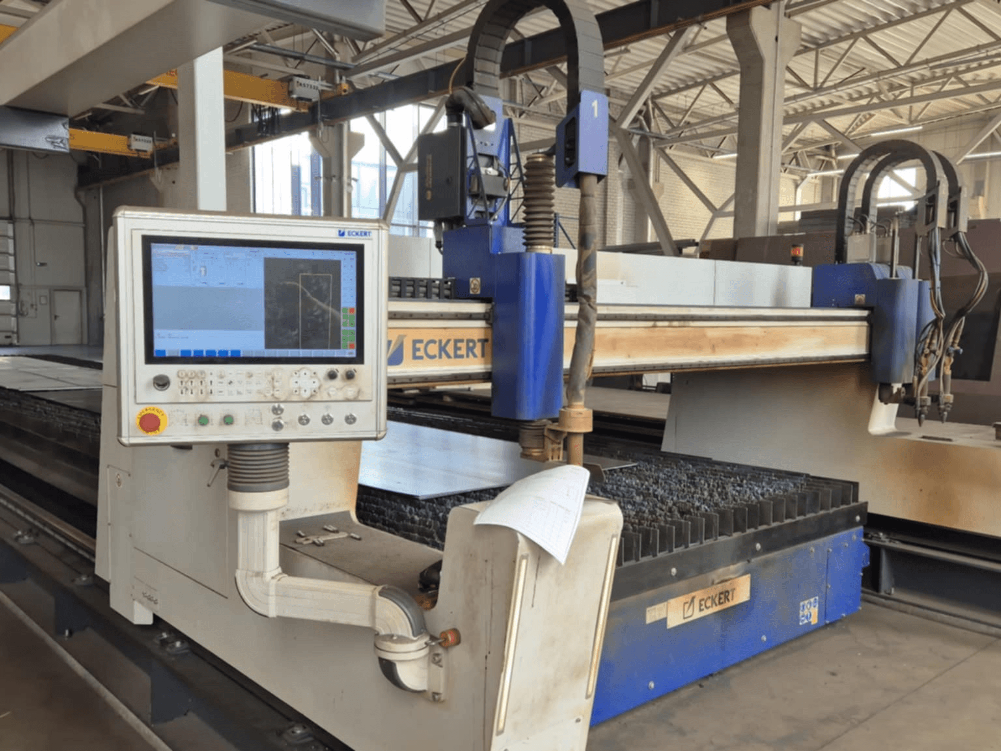 ECKERT CNC kesim makinesi kontrol panelinin önden görünümü, dokunmatik ekran ve çeşitli işlem düğmeleri içerir.