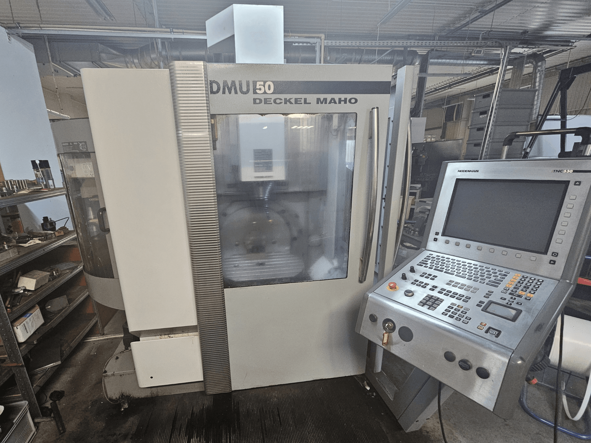 DMU 50 Deckel Maho CNC makinesi, kontrol paneli ve çalıştırma tuşları görünür şekilde önden görünüm, atölye ortamında.