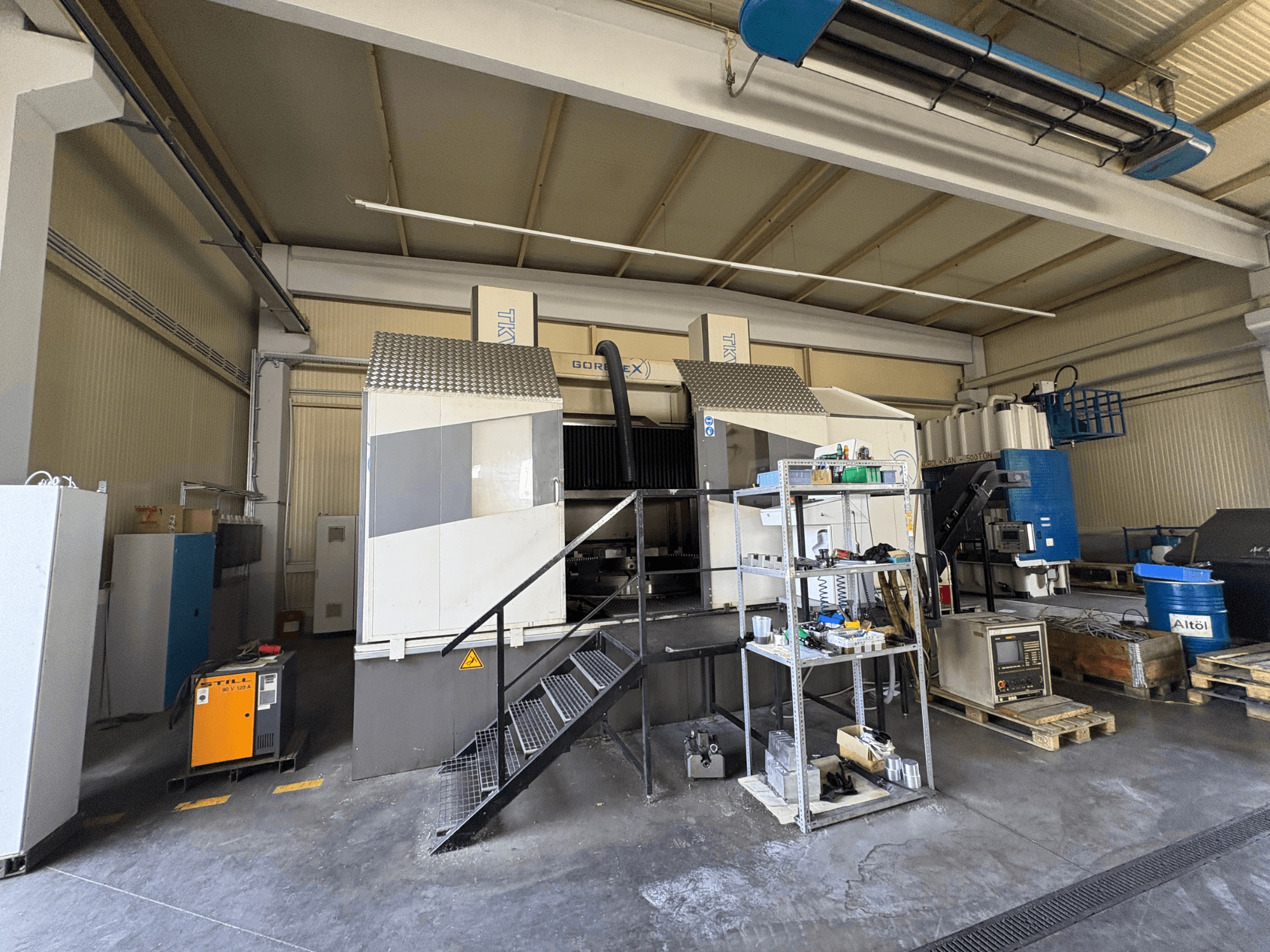 GORAT X makinesi ile endüstriyel işleme kurulumu, yandan görünüm; aletler, kontrol paneli ve raflardaki ekipmanları içerir.