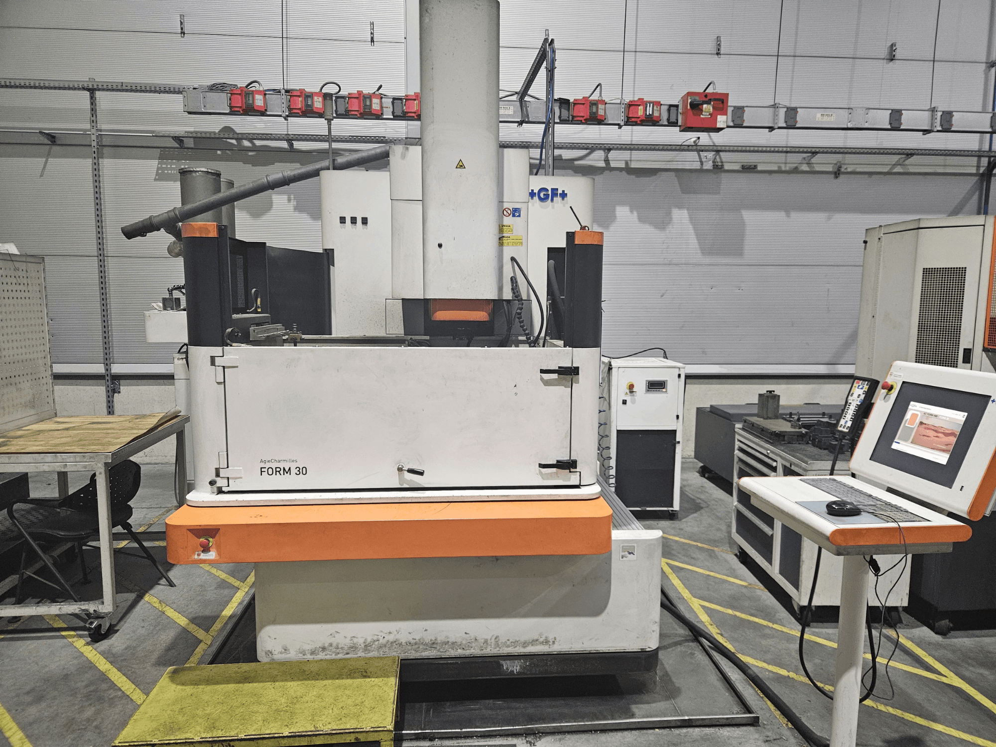 ApeqChemicals FORM 30 makinesi atölyede, kontrol paneli ve yan taraftaki çalışma masası ile önden görünüm.