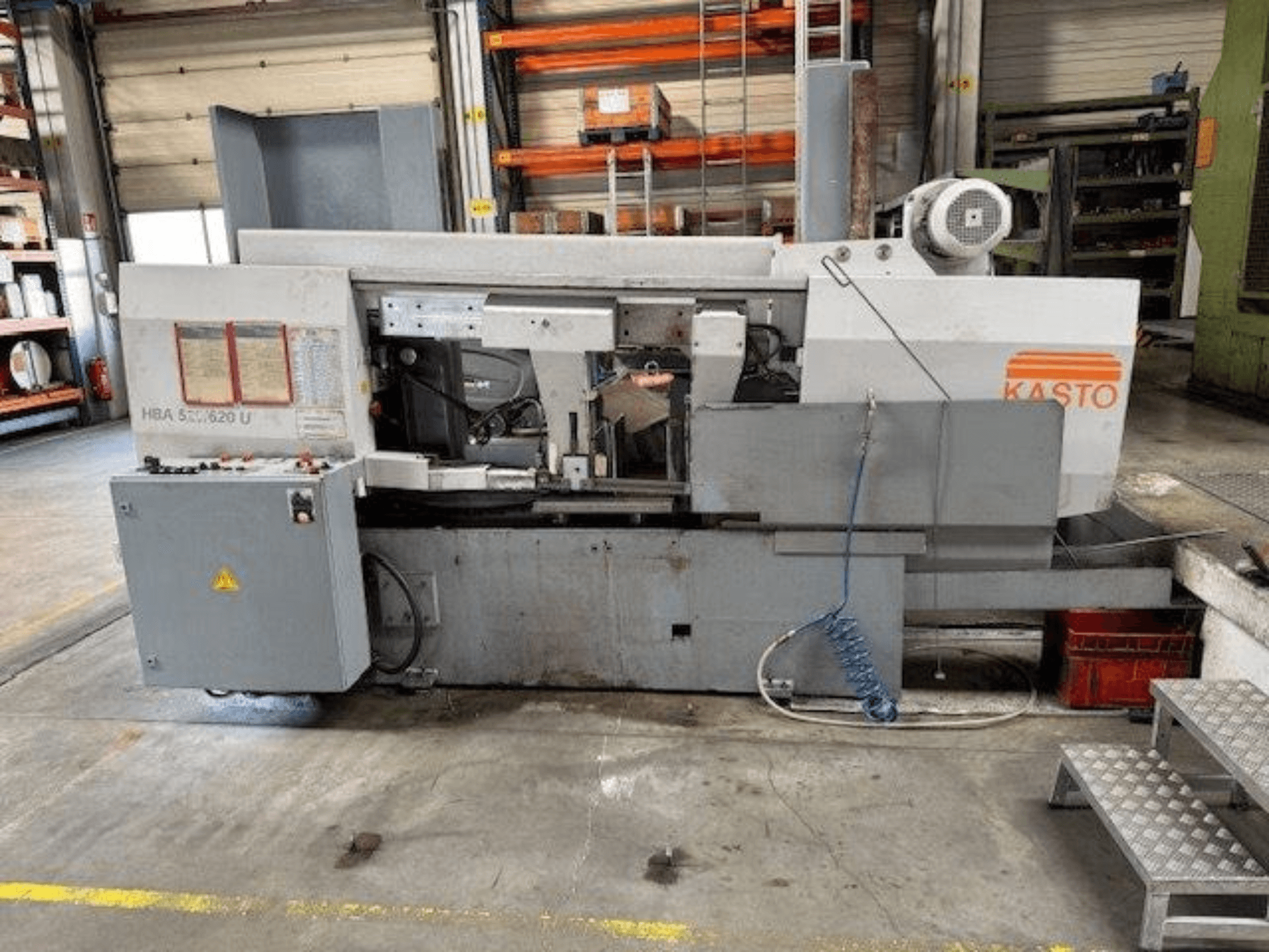 KASTO HBA 520/620 U metal şerit testere, yandan görünüm, atölye ortamında kontrol panelini ve kesim alanını gösterir.