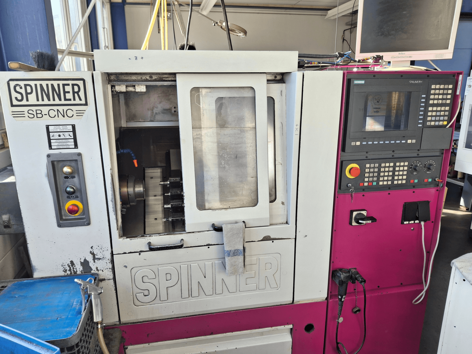 Yatay tornalama makinesi SPINNER SB-CNC, kontrol paneli, takım tutucu ve çalışma göstergelerini gösteren önden görünüm.