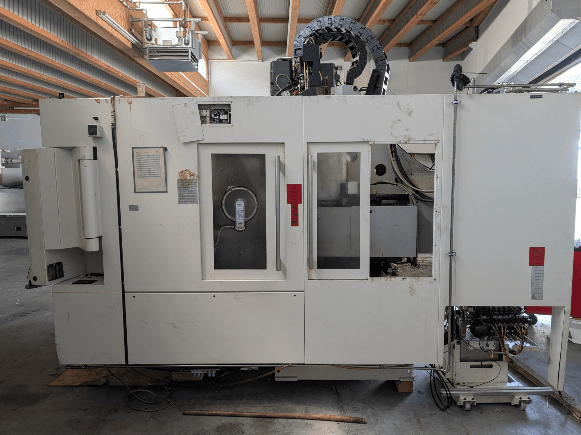 STAMA MC 326 dikey işleme merkezi, kontrol panelini, iş mili alanını ve makine üzerindeki çeşitli etiketleri gösteren yandan görünüm.