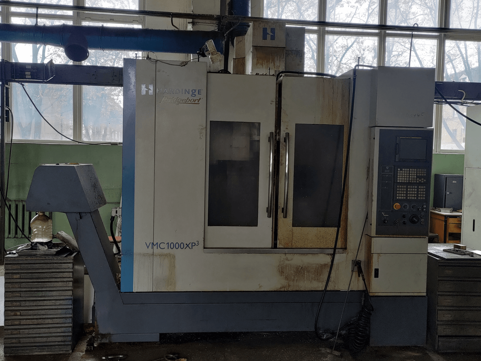 Bridgeport VMC1000 XP3 dikey işleme merkezinin önden görünümü; kontrol paneli ve hafif aşınma izleri görülmektedir.
