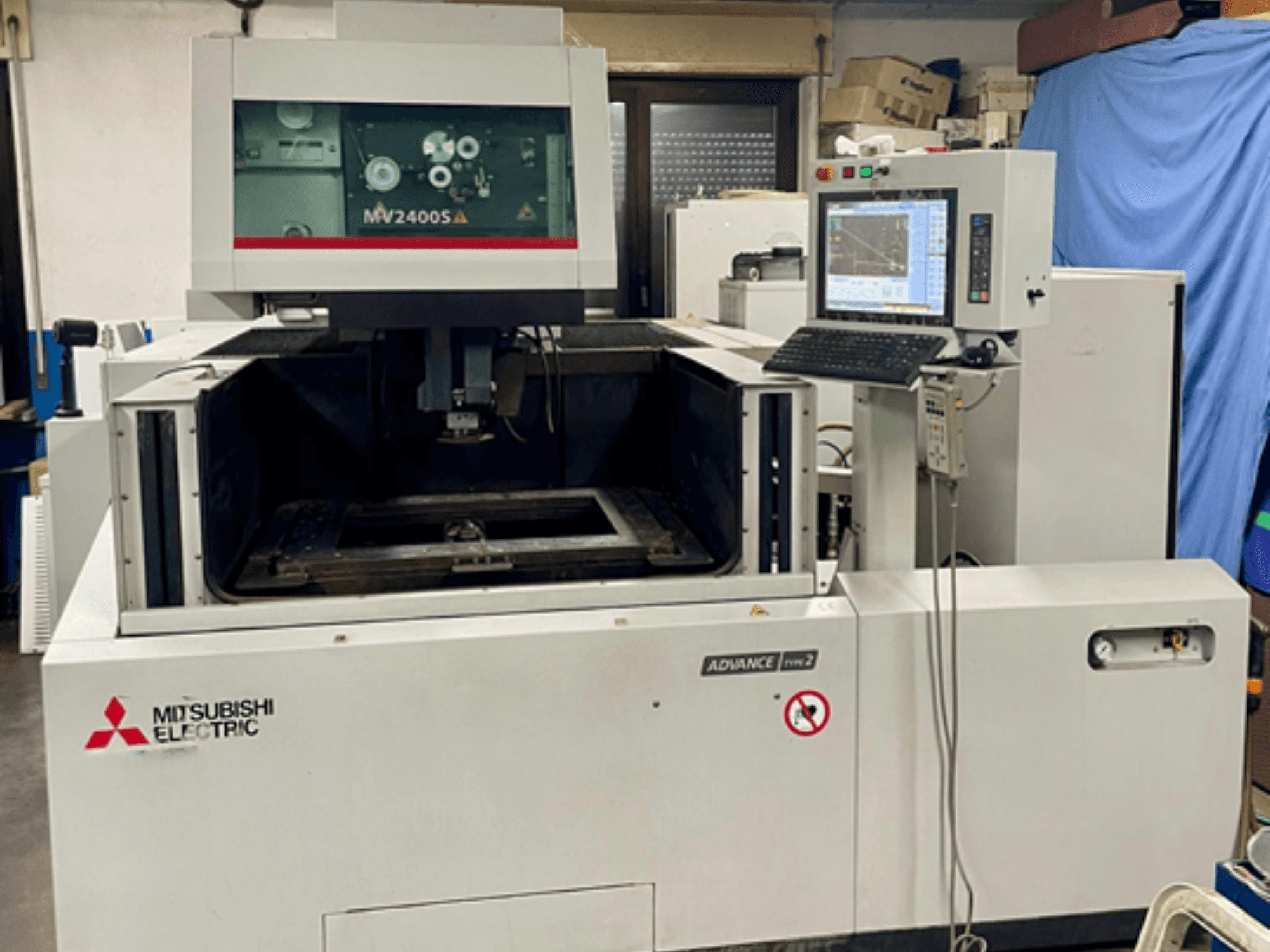 Mitsubishi MV 2400S Tel Erozyon makinesi, önden görünüm, kontrol paneli ve hassas kesim için görünür çalışma alanı.