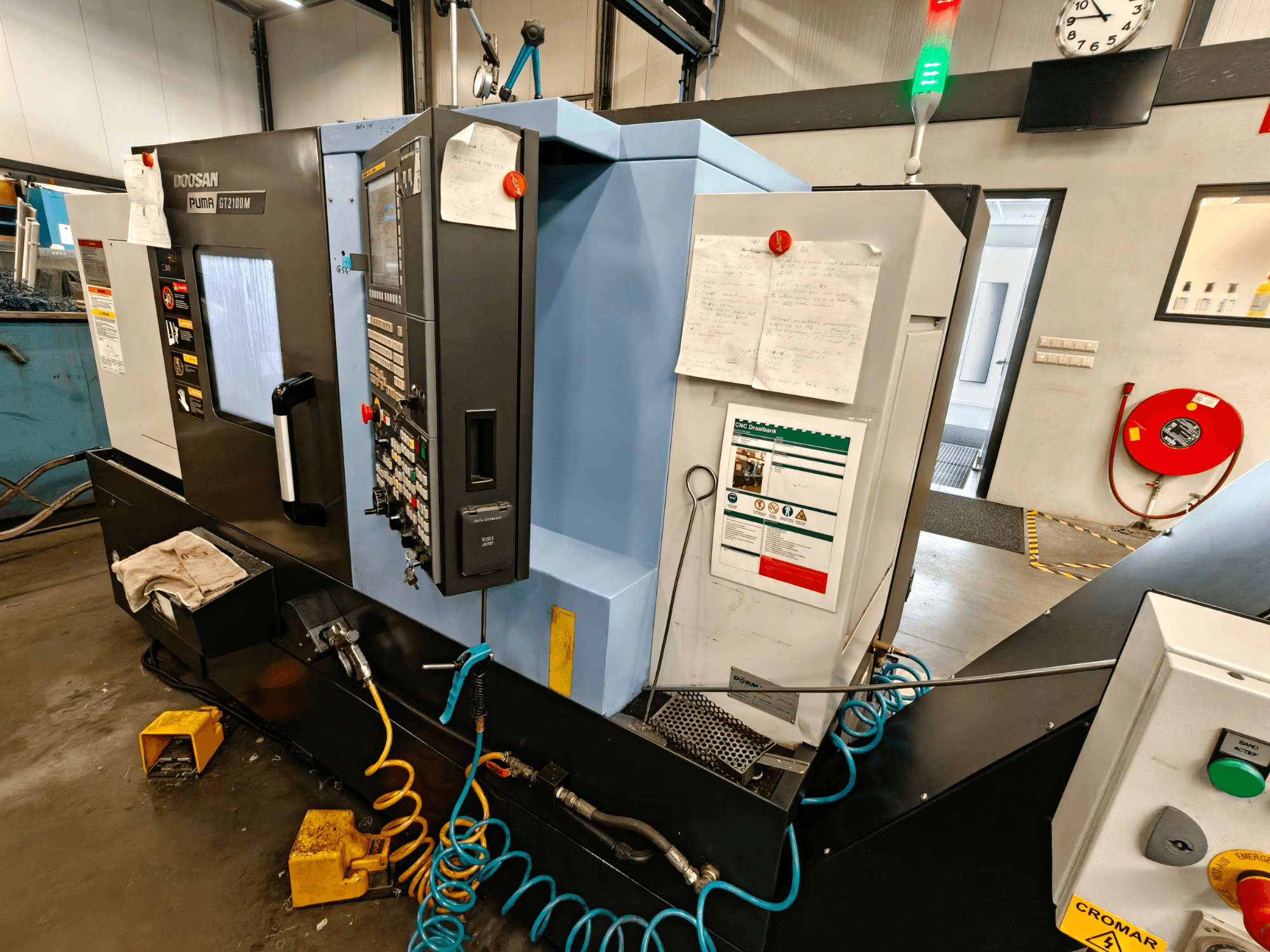 DOOSAN Puma GT 2100M yatay torna makinesinin önden görünümü, kontrol paneli, güvenlik özellikleri ve bakım notları görünür.