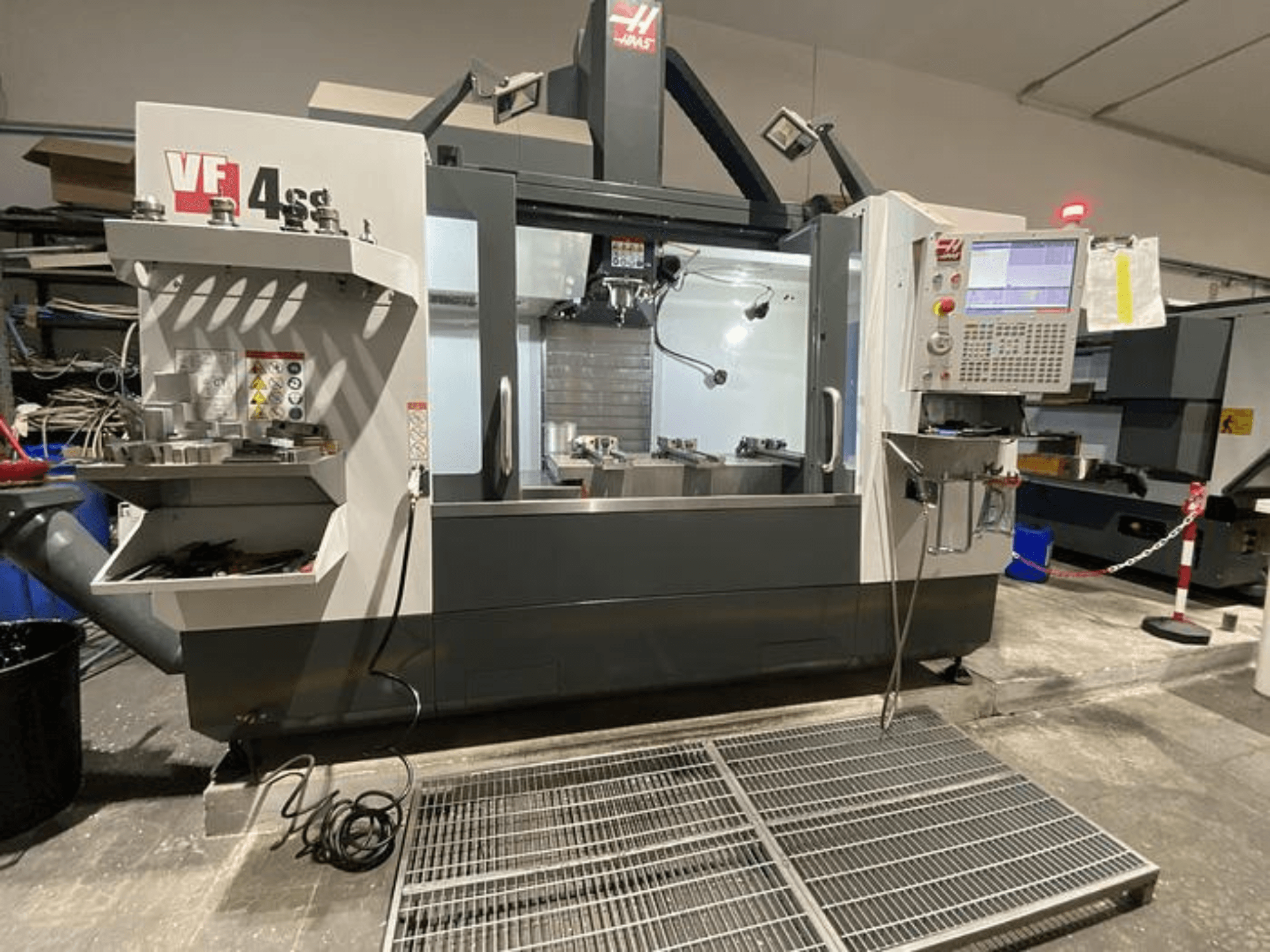 Haas VF-4SS CNC freze makinesi, önden görünüm, takım deposu, kontrol paneli ve atölye ortamında görünür çalışma alanı.
