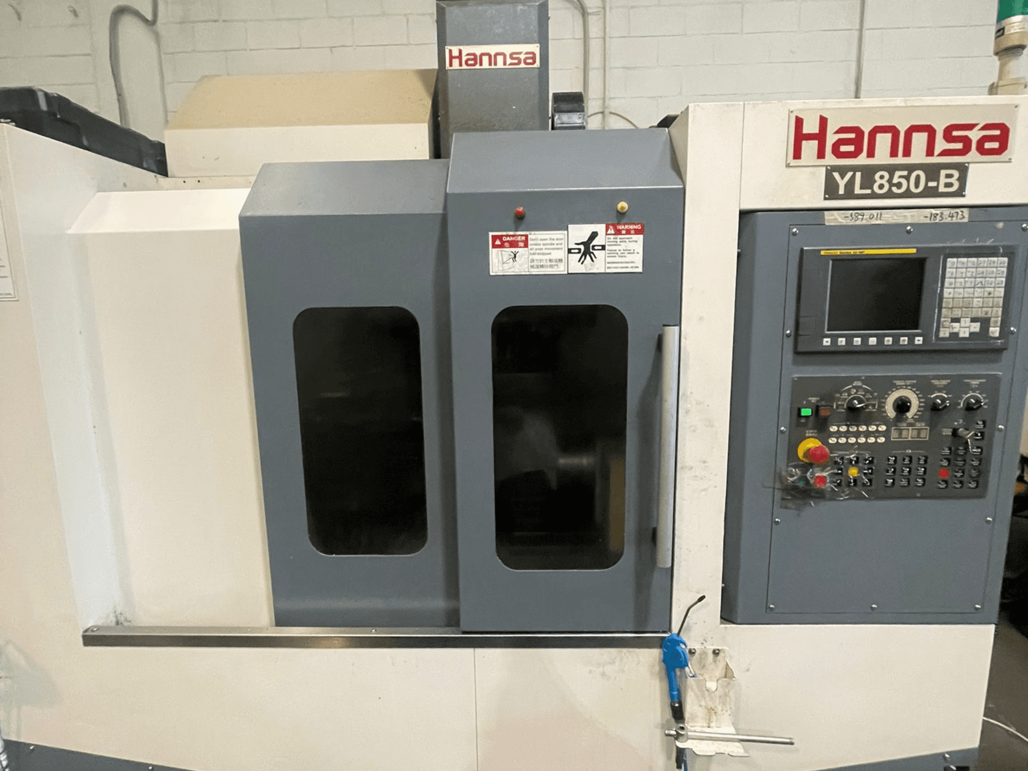 Dikey işleme merkezi HANNSA YL850-B, önden görünüm, kontrol paneli, çalıştırma düğmeleri ve çift gözlem penceresi.