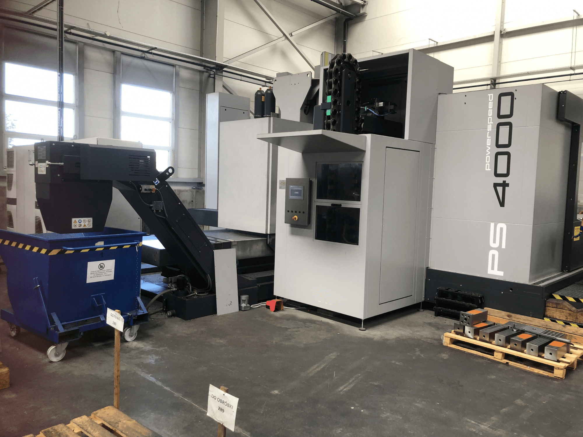 Bir fabrika ortamında çekilmiş, kontrol paneli, konveyör ve iş parçalarını gösteren SHW PowerSpeed 4000 yatay işleme merkezi.