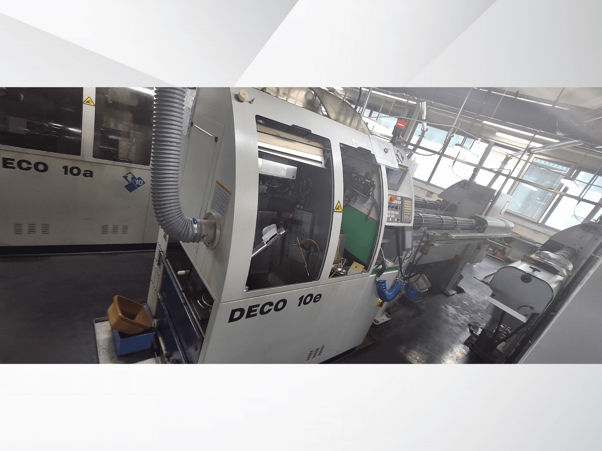 DECO 10e CNC makinesinin yandan görünümü, kontrol paneli, yeşil iç kısım ve bağlı egzoz hortumu.