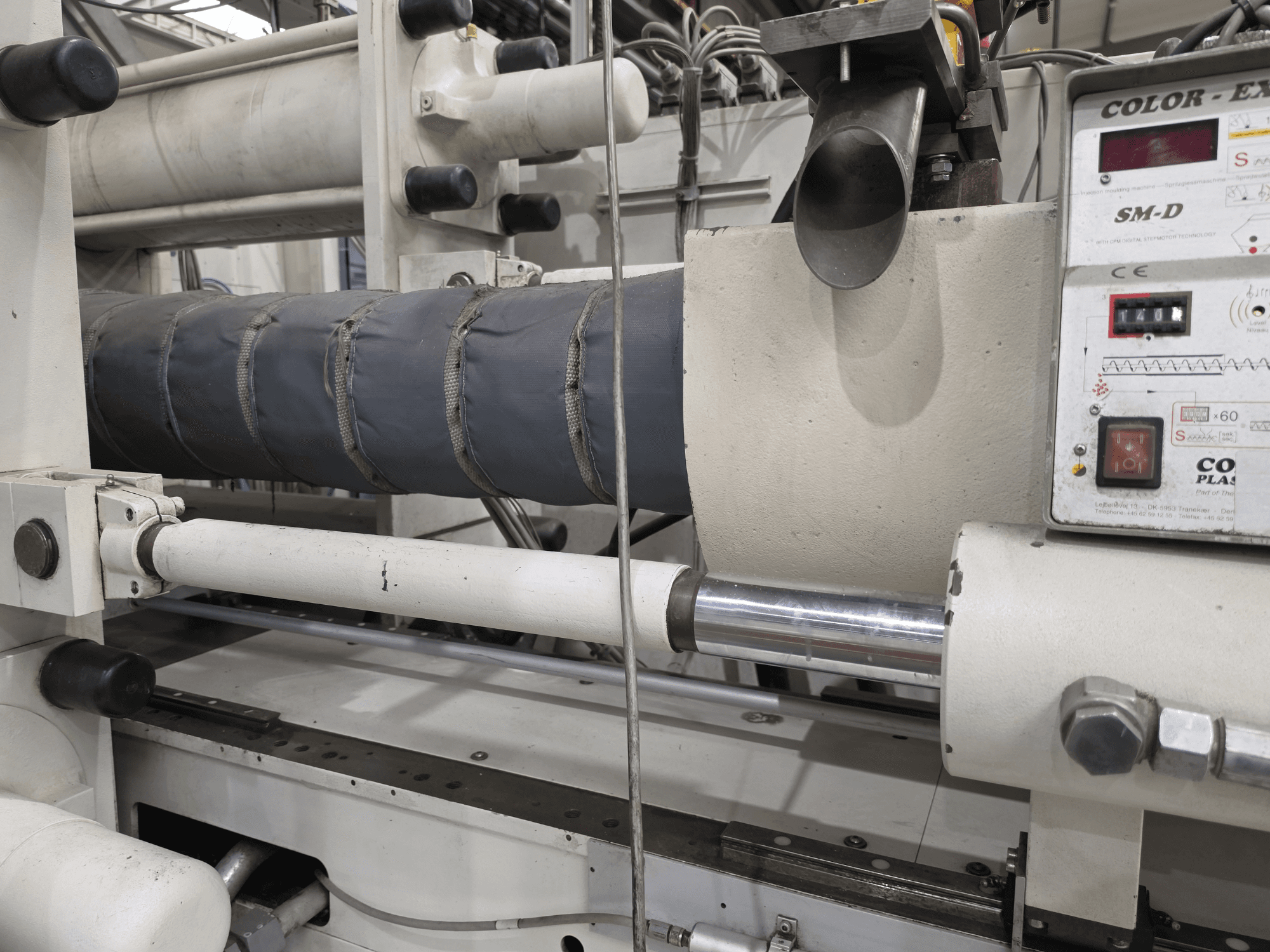 Krauss Maffei 350-3000 CX hidrolik enjeksiyon kalıplama makinesi, sıcaklık kontrol panelini ve ısıtma elemanlarını gösteren yandan görünüm.