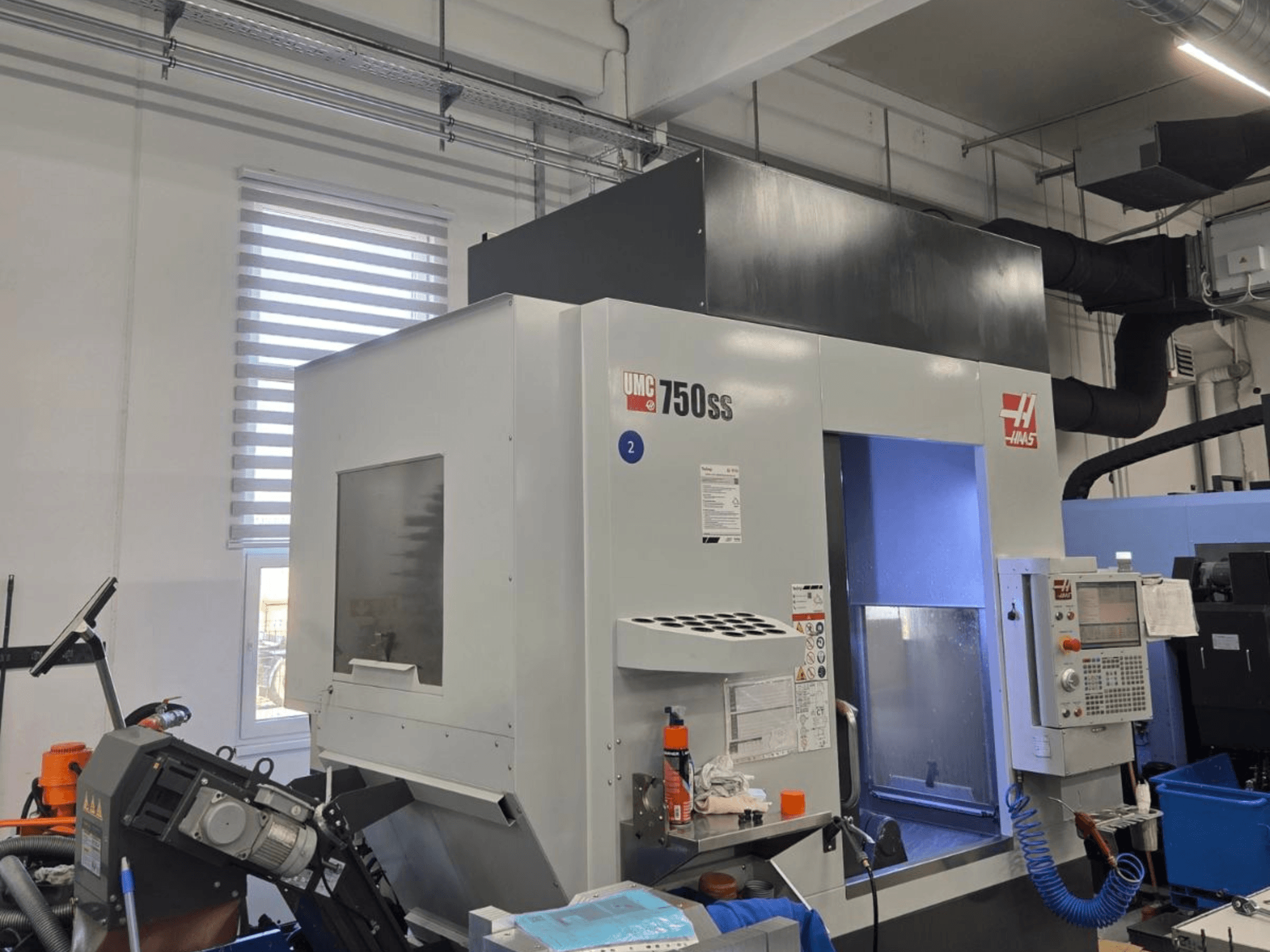 Haas UMC-750SS dikey işleme merkezi, önden görünüm, kontrol paneli ve işleme alanına açık erişim.