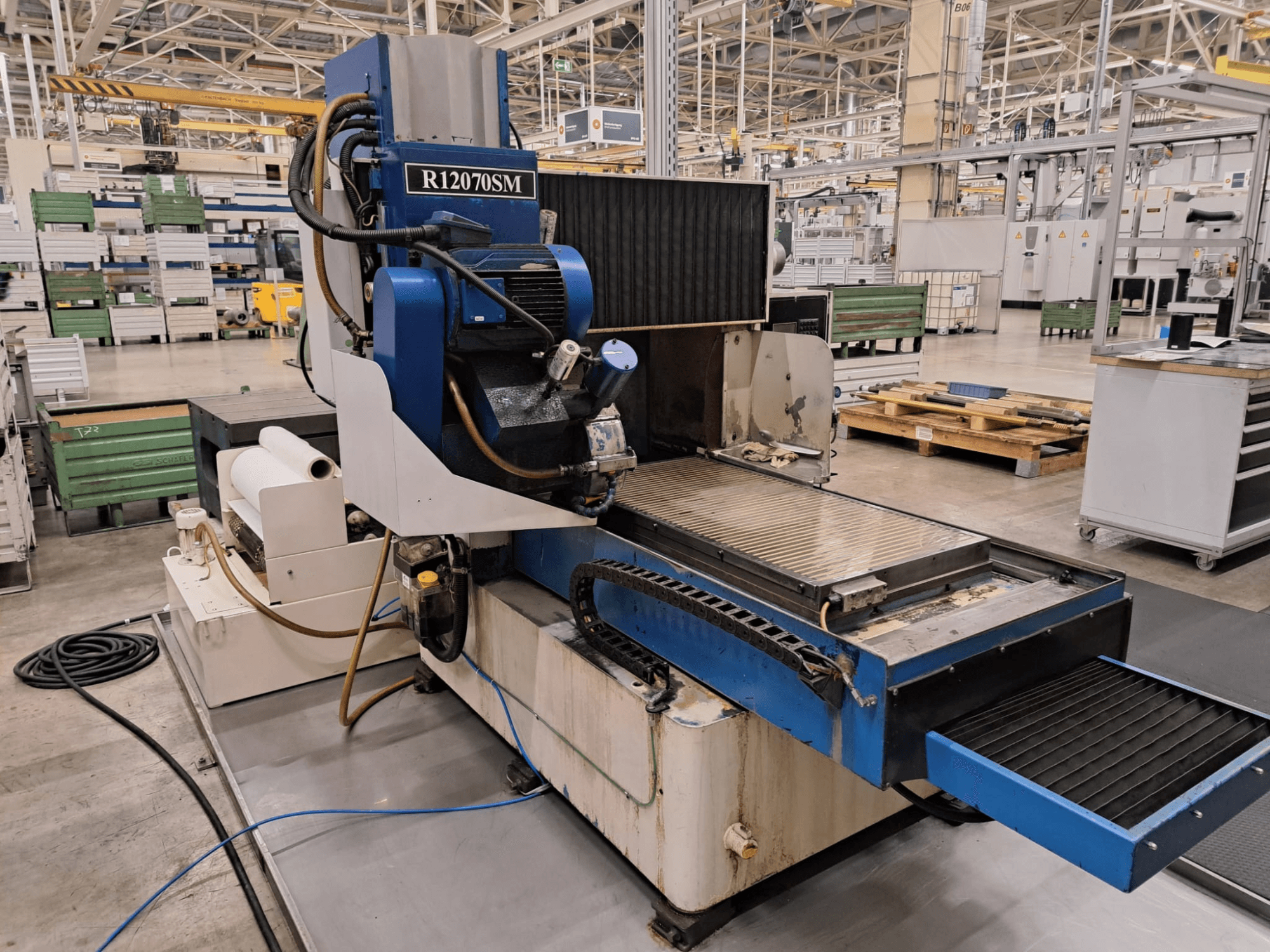 Fabrika ortamında bulunan LGB R12070SM yüzey taşlama makinesi, önden bakıldığında, çalışma özellikleri ve yerleşim düzeni görülebilir.