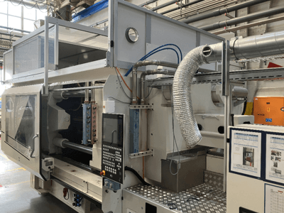 Brand X'ten endüstriyel makine, fabrika ortamında kontrol panelini, kanal sistemini ve makine bileşenlerini gösteren yandan görünüm.