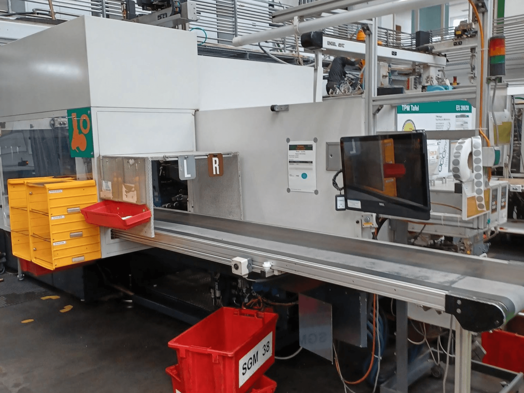 Sarı ve kırmızı kutulara sahip endüstriyel ayıklama makinesi, yandan görünüm, bir kontrol monitörü ve ayıklama için etiketlenmiş bölmeler.