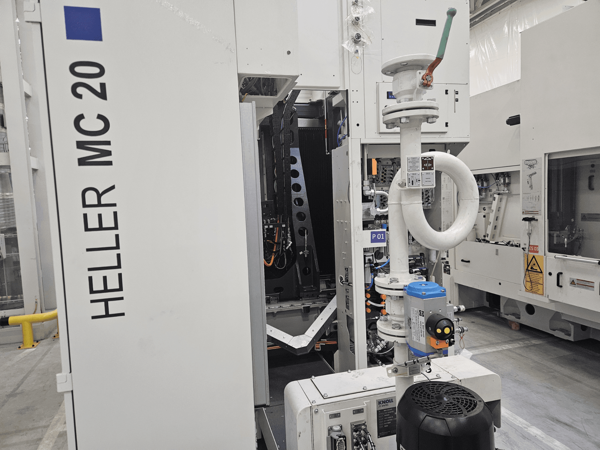 Heller MC 20 makinesi fabrika ortamında, kontrol paneli ve mekanik bileşenleri yandan görünümle sergiliyor.