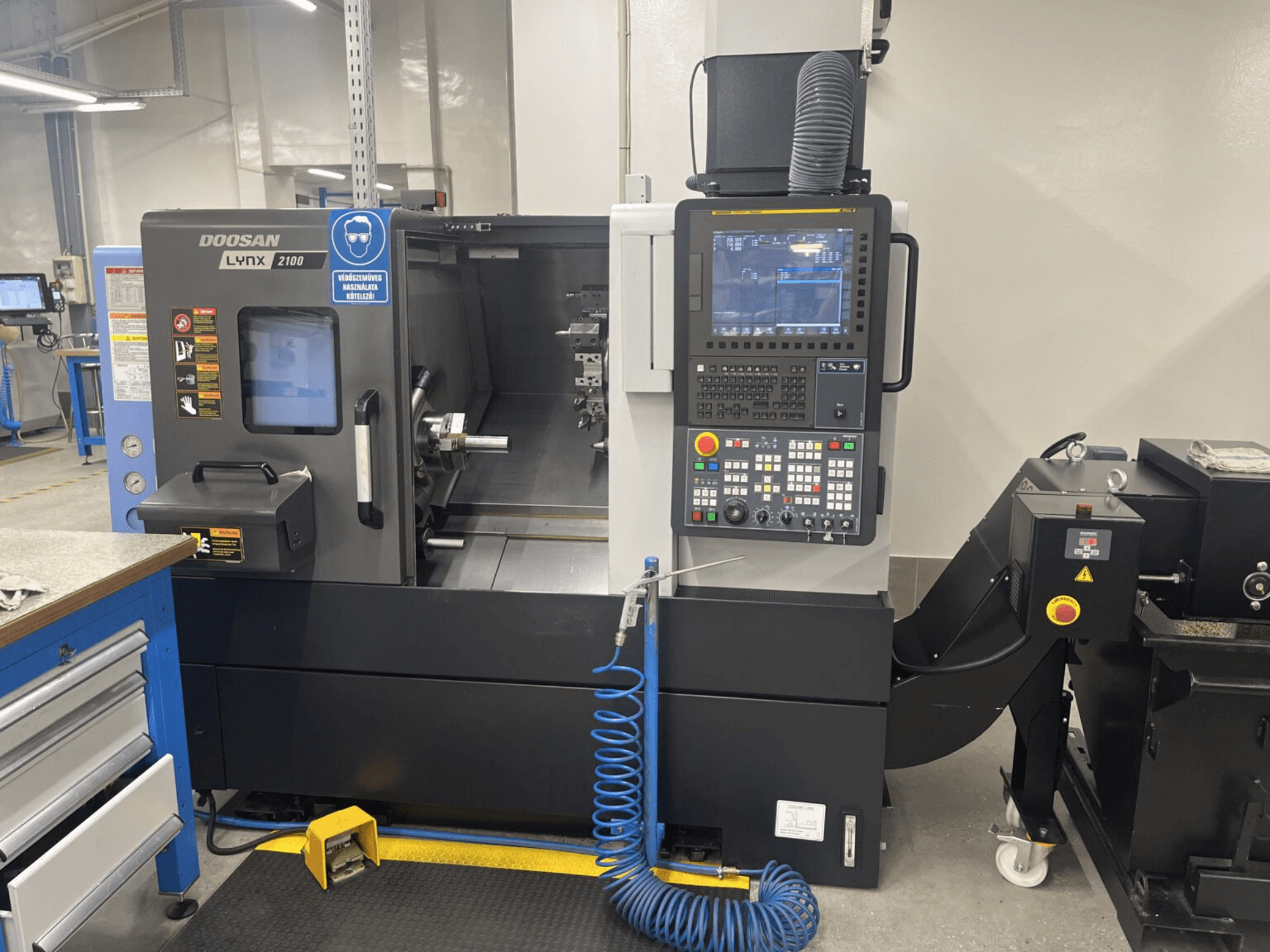 DOOSAN Lynx 2100A yatay torna tezgahının önden görünümü, kontrol paneli ve iş mili alanı ile dikkat çekici güvenlik özellikleri.