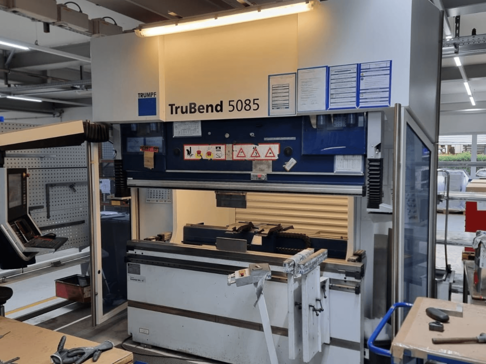 TRUMPF TruBend 5085 bükme makinesi, önden görünüm, atölye içindeki kumanda paneli, kumanda istasyonu ve güvenlik uyarıları.