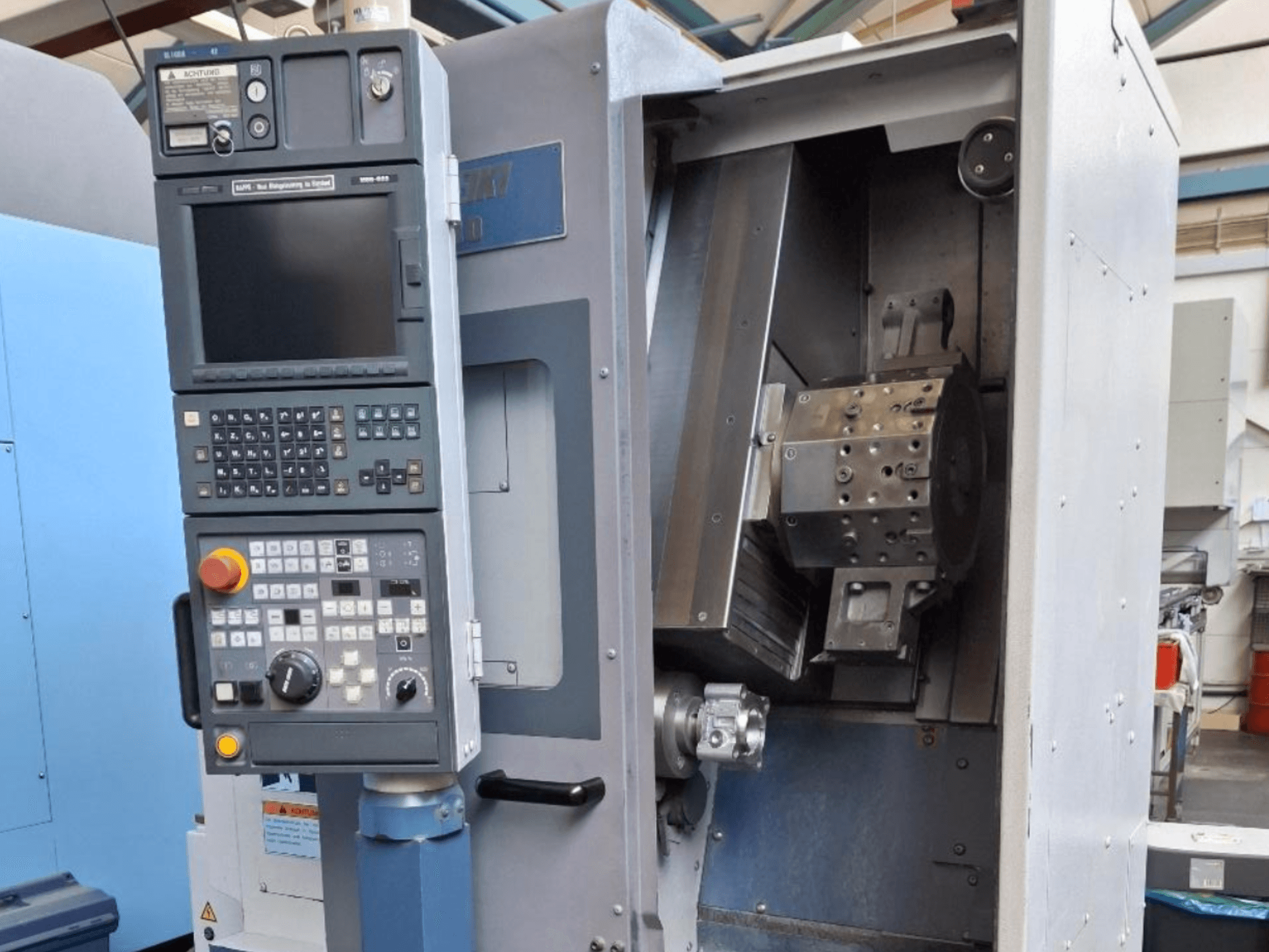 MORI SEIKI SL 1000 yatay torna makinesi önden görünüm, kontrol paneli ve ayrıntılı iç mekanizma.