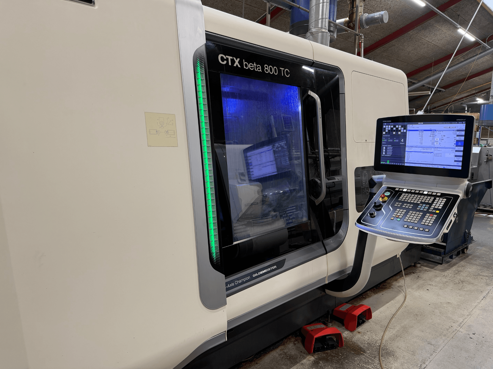 CTX beta 800 TC CNC makinesinin yandan görünümü, dijital kontrol paneli ve ışıklı yeşil güvenlik göstergesi.